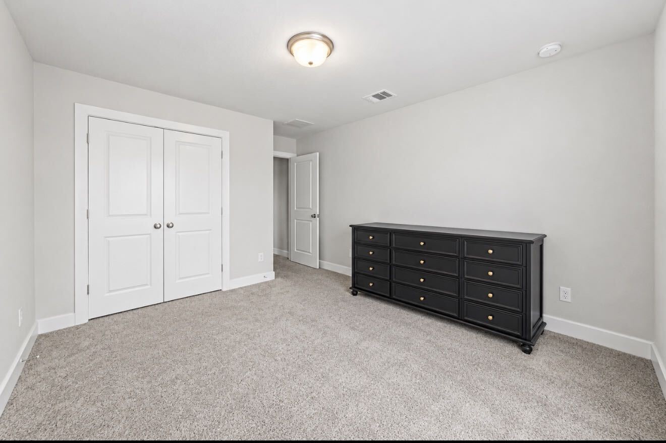 One of three secondary bedrooms upstairs, this room offers plush carpet and a double-door closet.