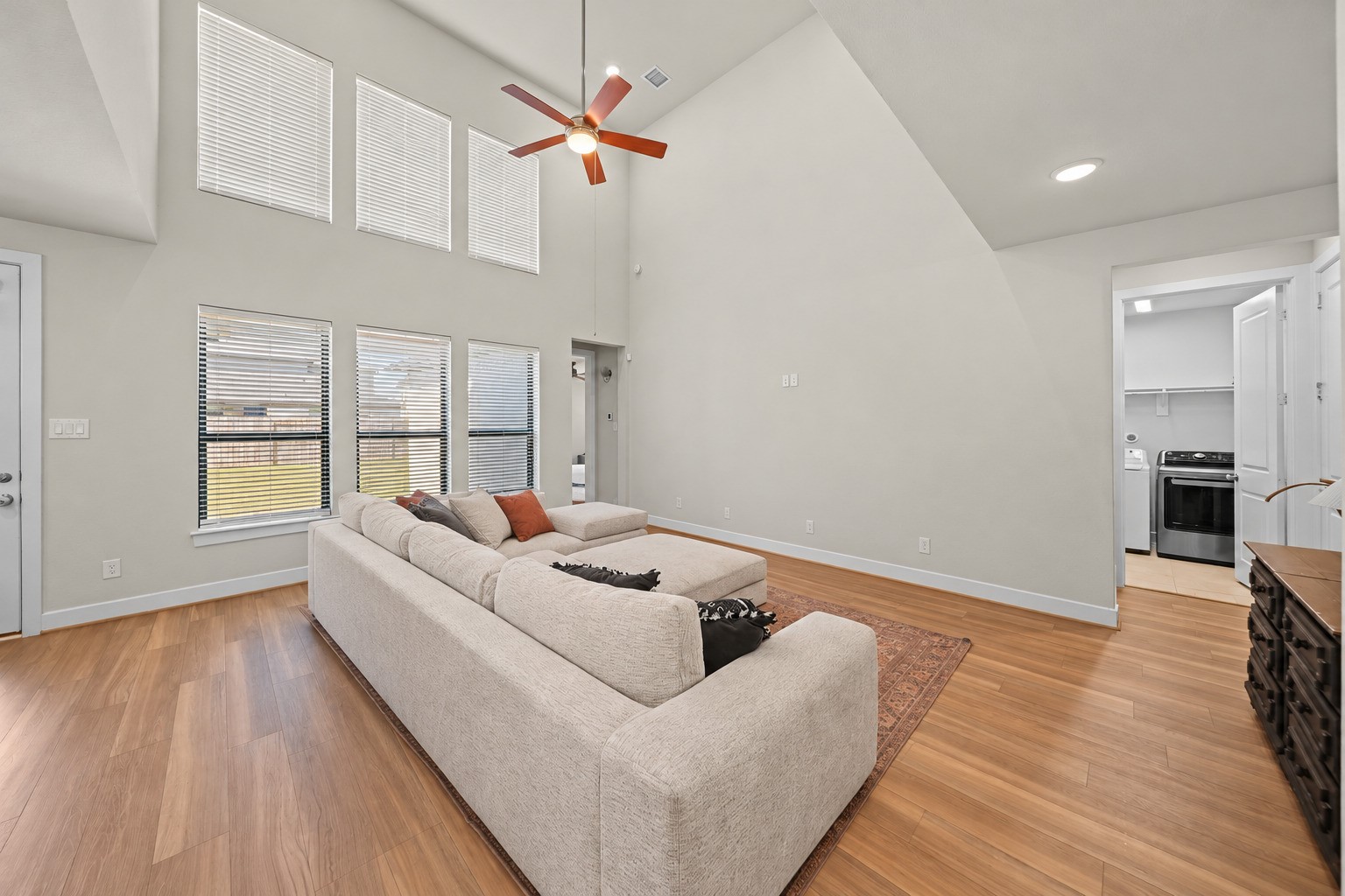 Two-story windows with blinds bring in plenty of daylight and show off the height of this open family room. Two-story windows with blinds bring in plenty of daylight and show off the height of this open family room.