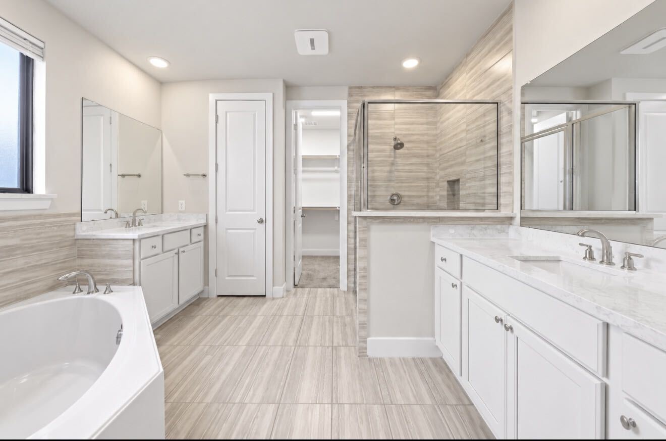 The primary bath offers double vanities, a soaking tub, a separate glass-enclosed shower, and direct access to the walk-in closet, which makes daily routines easy. The primary bath offers double vanities, a soaking tub, a separate glass-enclosed shower, and direct access to the walk-in closet, which makes daily routines easy.