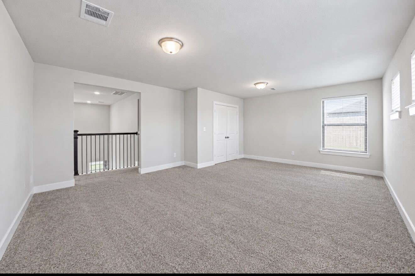 Upstairs, a spacious game room offers flexible space for movie nights, playtime, or a hangout spot, with a window for natural light.