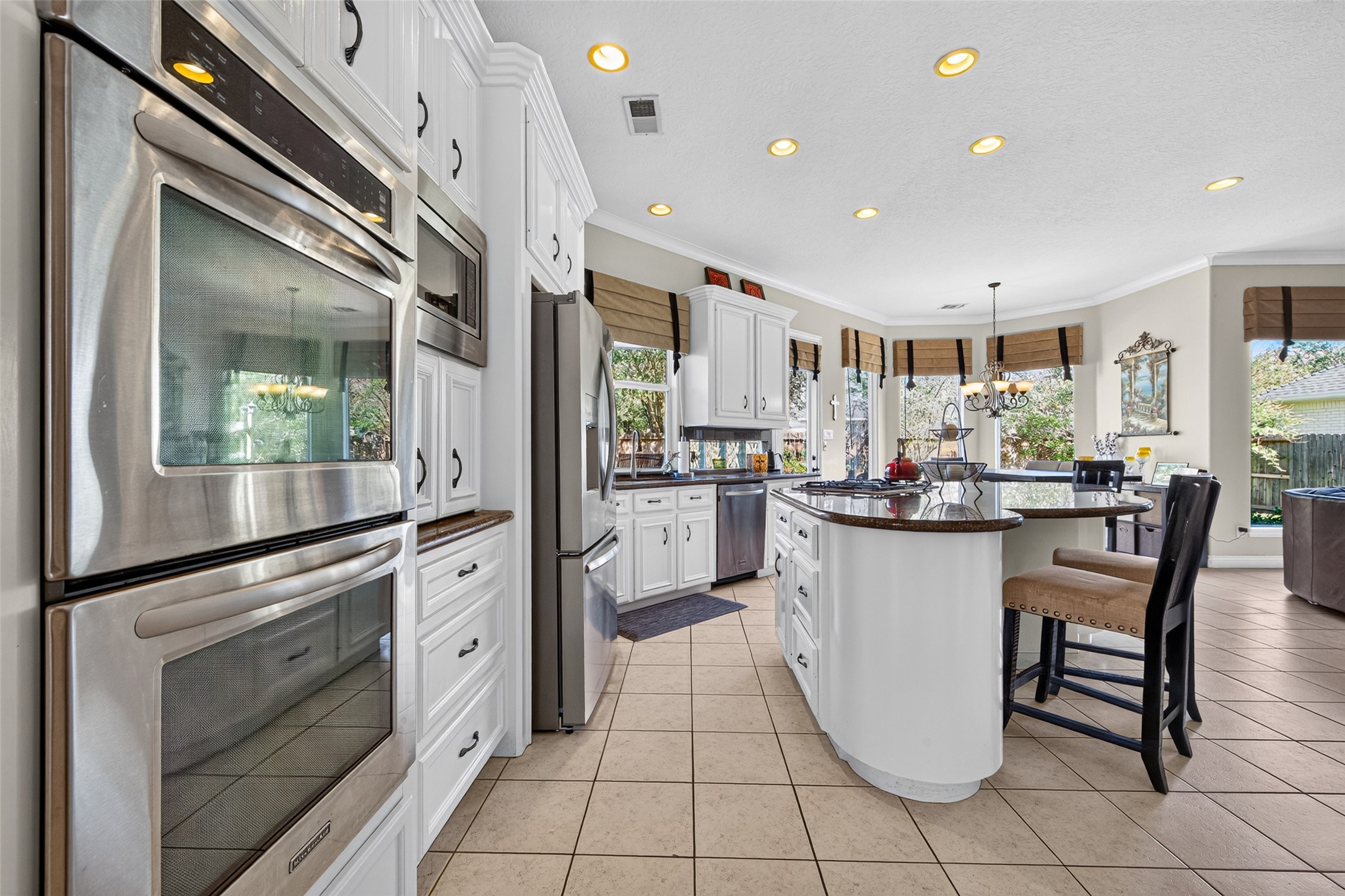 Double-ovens make for easy entertaining during the holidays and get togethers.  The walls of widows in this home brings in so much natural light.
