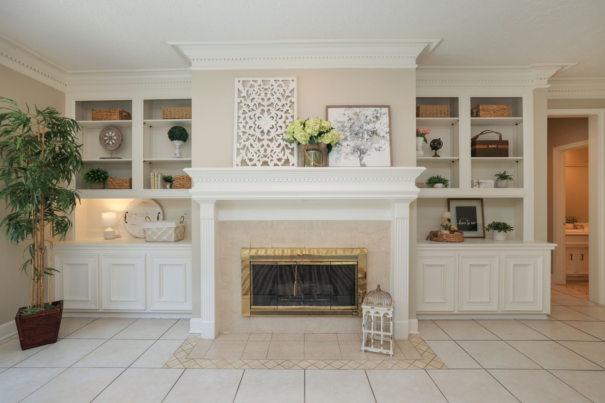 Elegant marble fireplace surrounded by custom built-insan impressive focal point in the family room.
