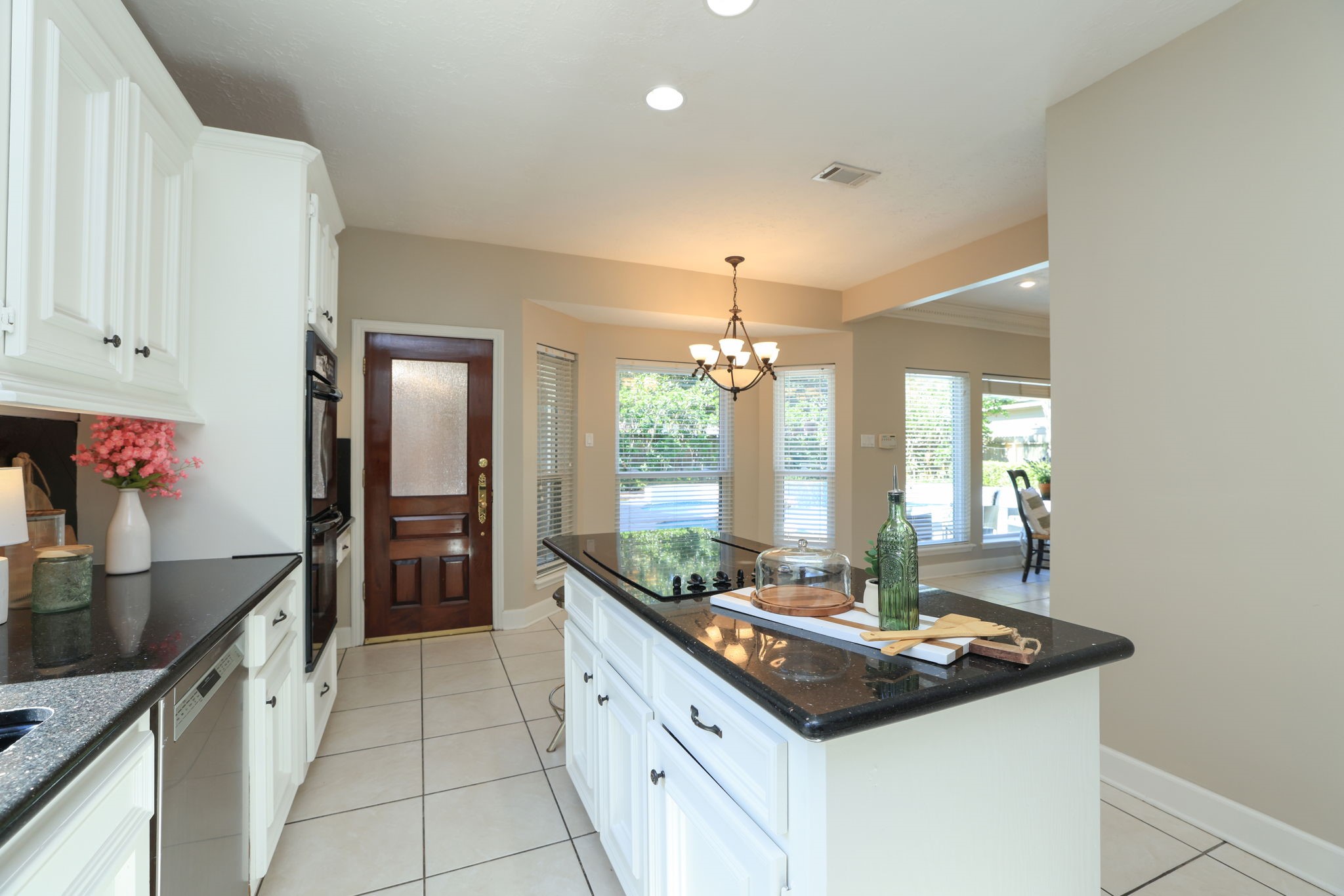 Spacious kitchen with center island and bright breakfast nook overlooking the pool and patio area.