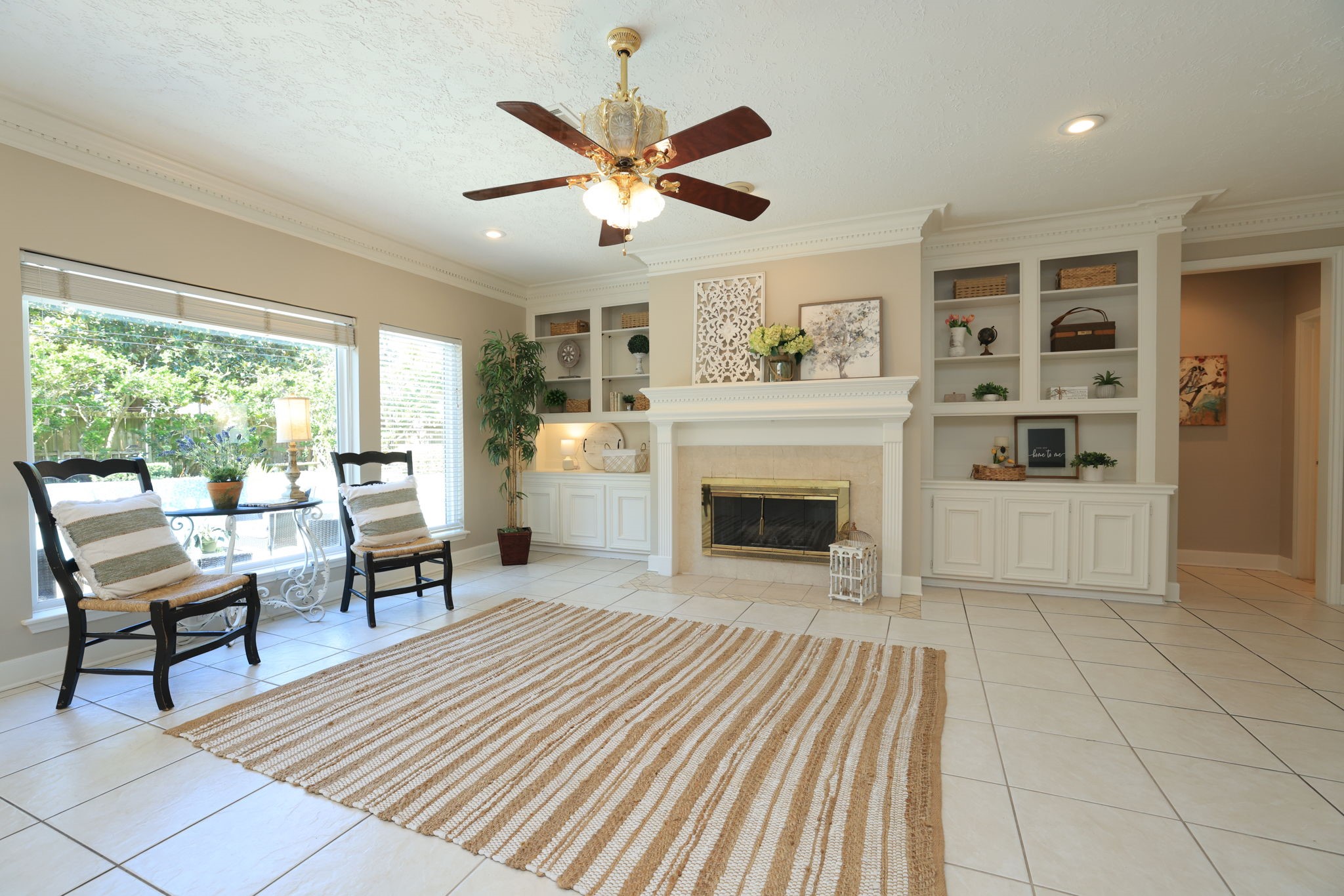 Wall of windows fills the space with natural light, showcasing the detailed millwork and open built-in shelving.