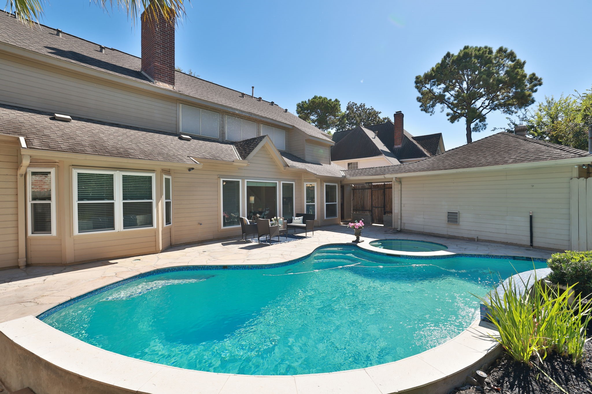 Sparkling pool and spa with a wide flagstone deck, perfect for outdoor dining, relaxing, or entertaining in your private backyard retreat.