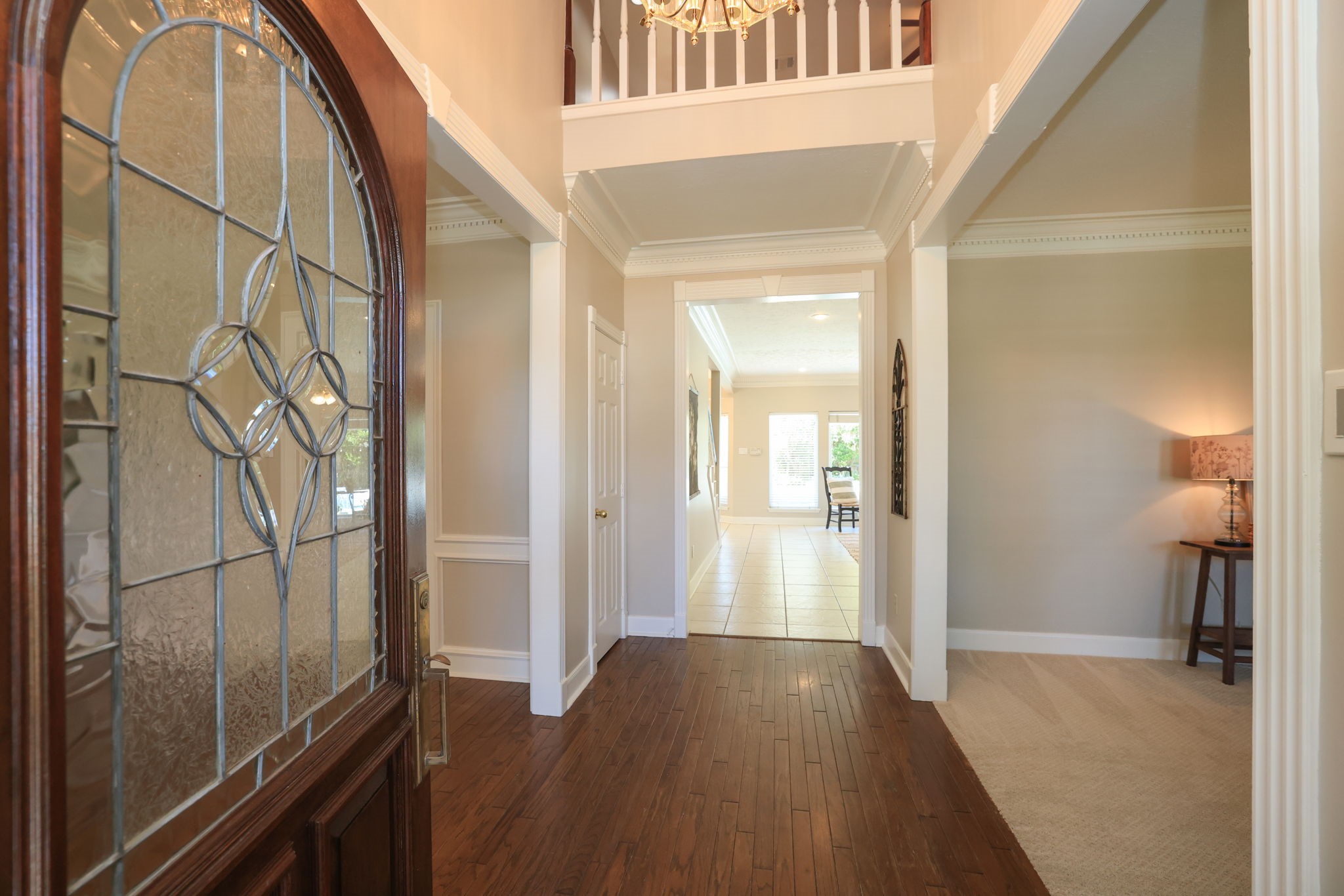 Grand entry opens to the living and dining areas, featuring crown molding and a view through to the family room.
