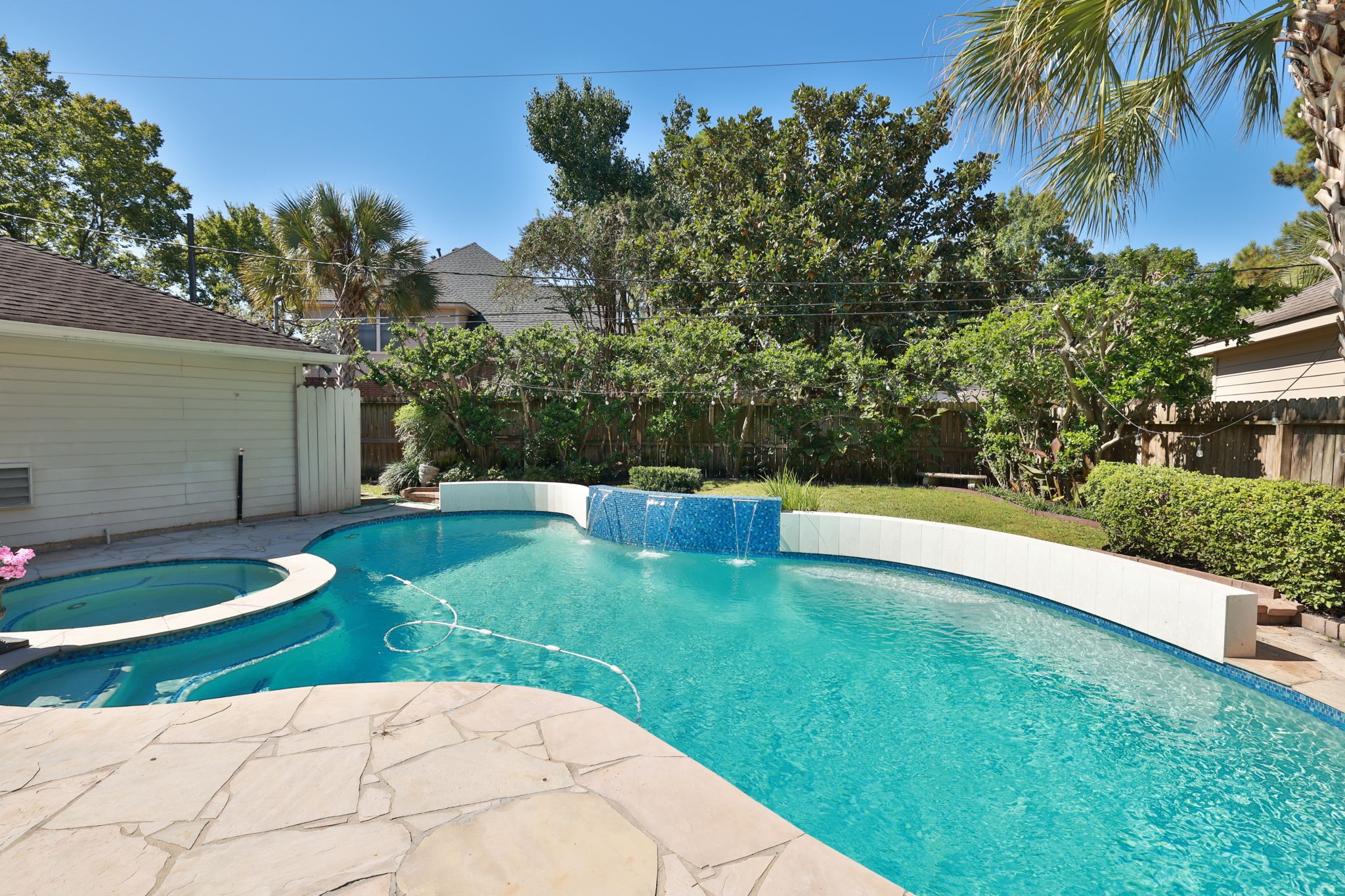 A perfect place to unwind  sparkling pool, palm trees, and private fenced yard complete this inviting outdoor living space.