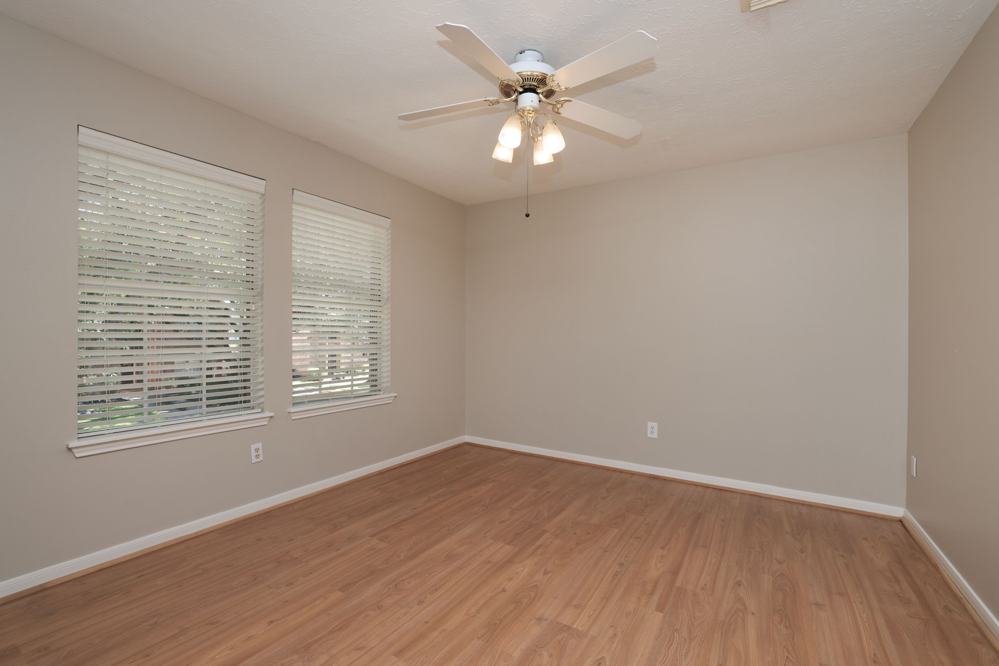 Light and airy with updated flooring, ceiling fan, and soft neutral color palette.