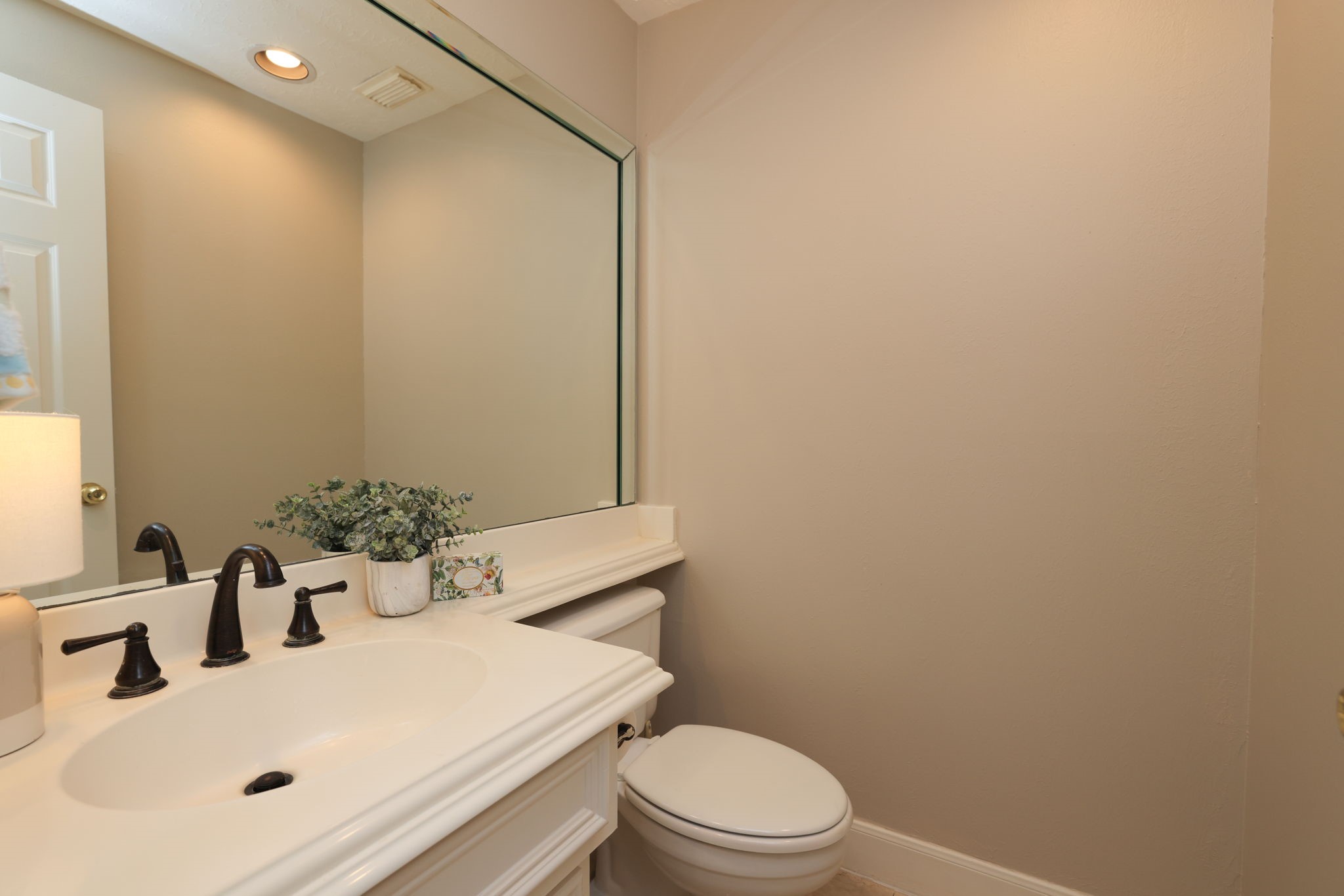 Charming powder bath on the main floor with updated fixtures and framed mirror.