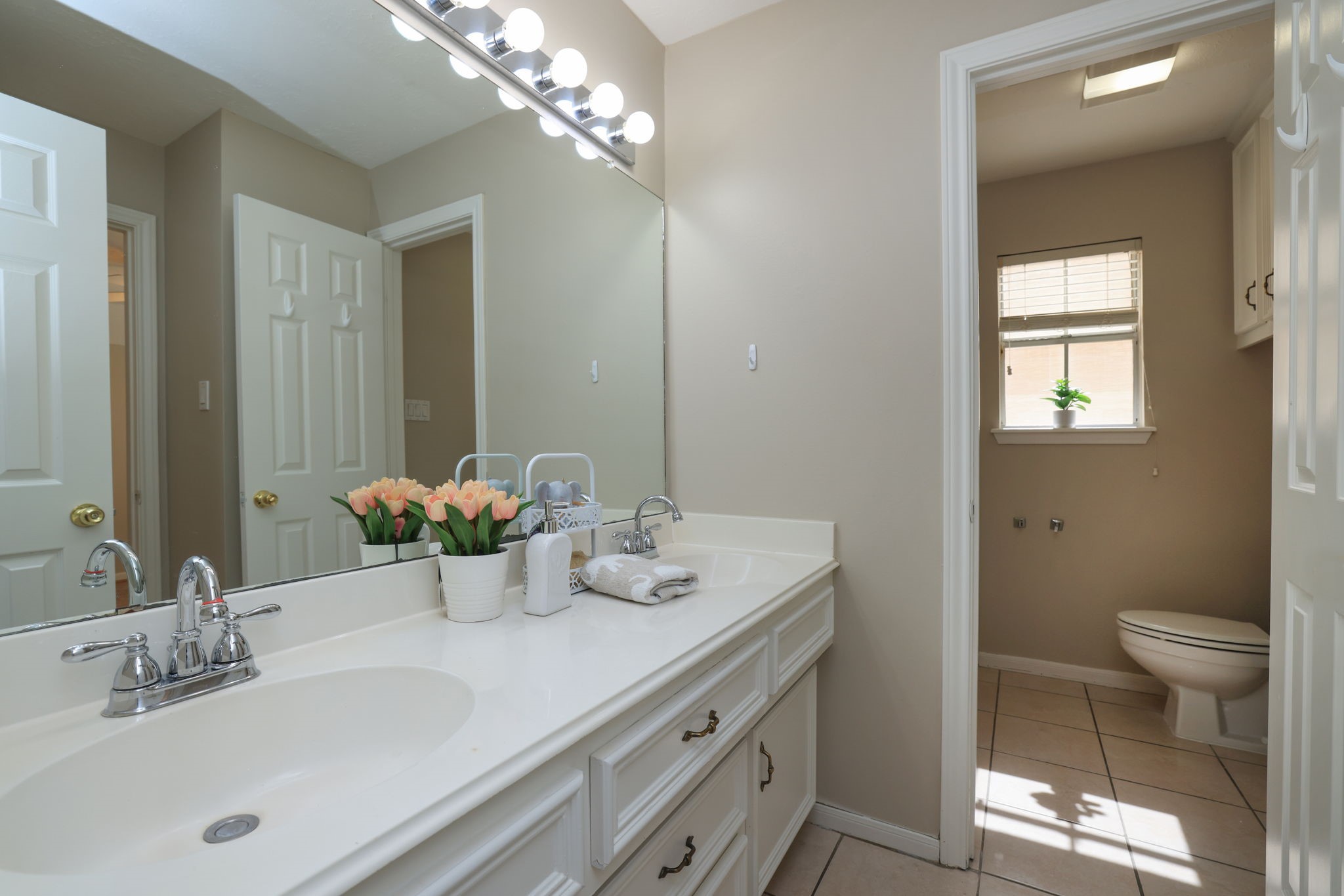 Large Upstairs bath with dual sinks, extended vanity, and separate area for shower and commode.