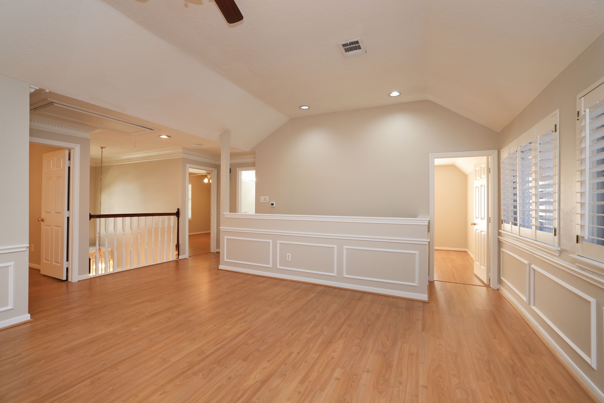 Beautifully detailed with chair rail molding and recessed lighting, this open game room overlooks the entryway below.