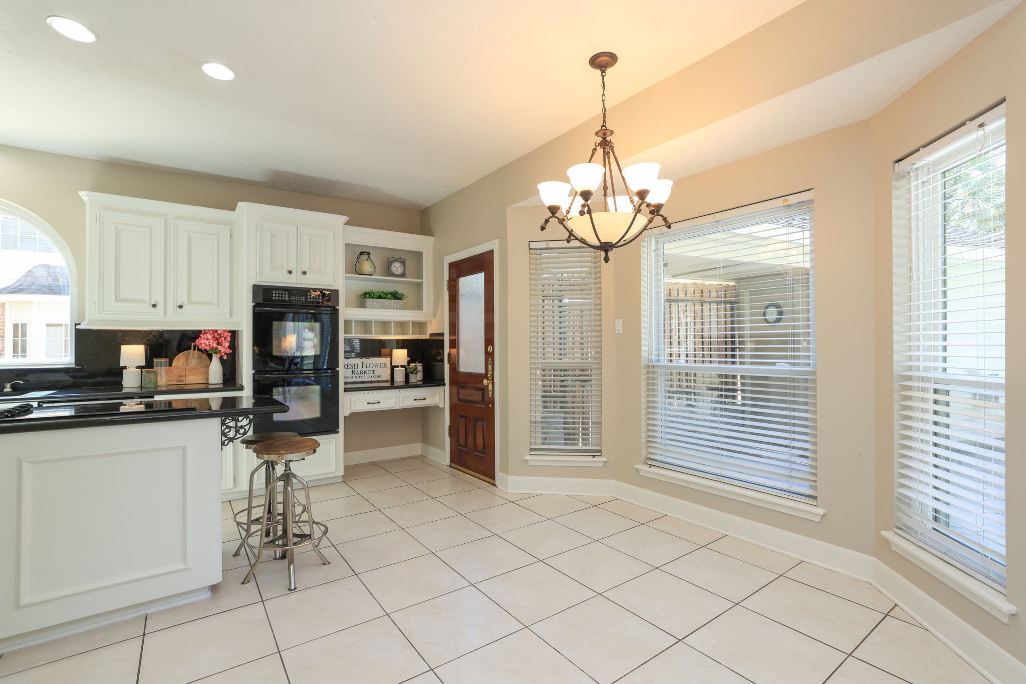Charming breakfast nook surrounded by bay windows overlooking the backyard and pool area.