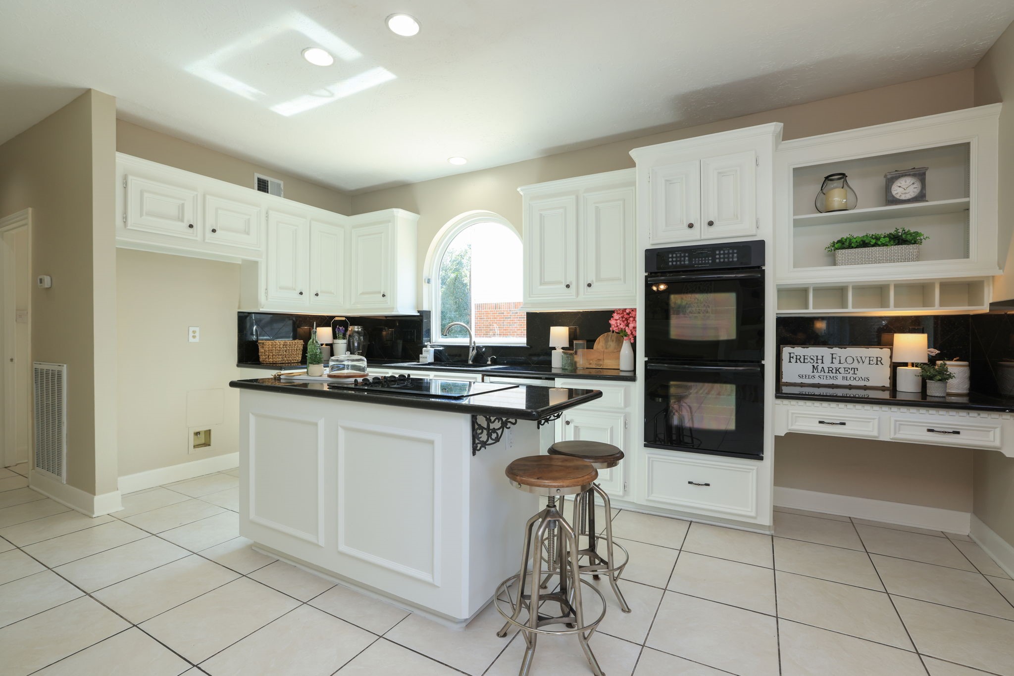 Crisp white cabinetry, granite counters, and built-in double ovens make this kitchen both functional and stylish.