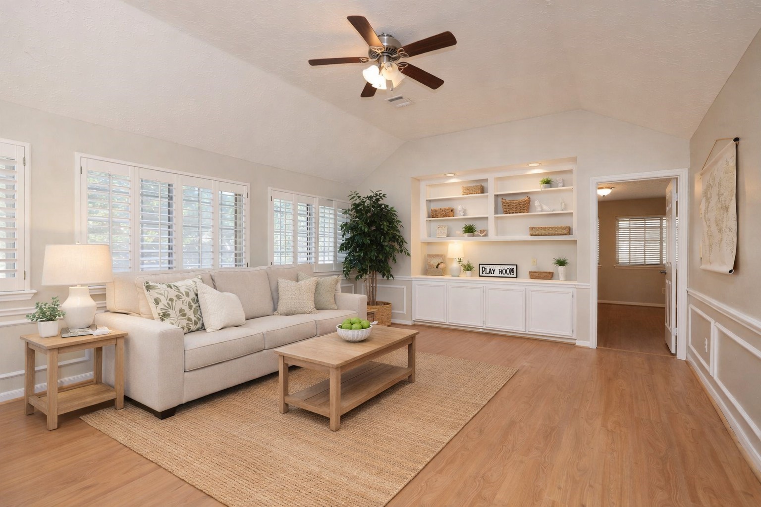 Virtually staged - Spacious upstairs game room with wood-look flooring, custom built-ins, and plantation shuttersideal for a playroom or media space.