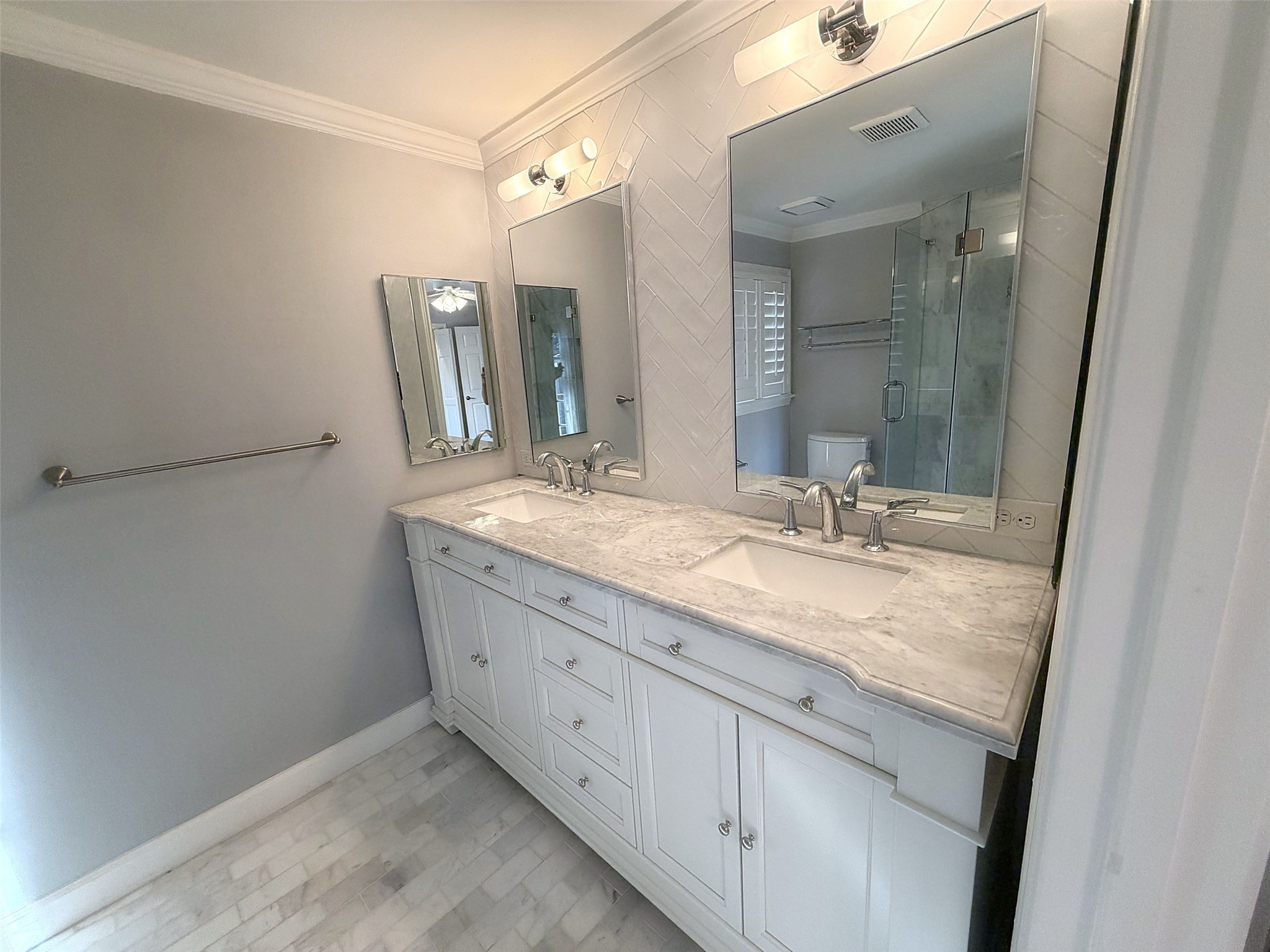 Primary Bathroom: Renovated bathroom with a double-sink vanity, marble countertops, and elegant finishes.
