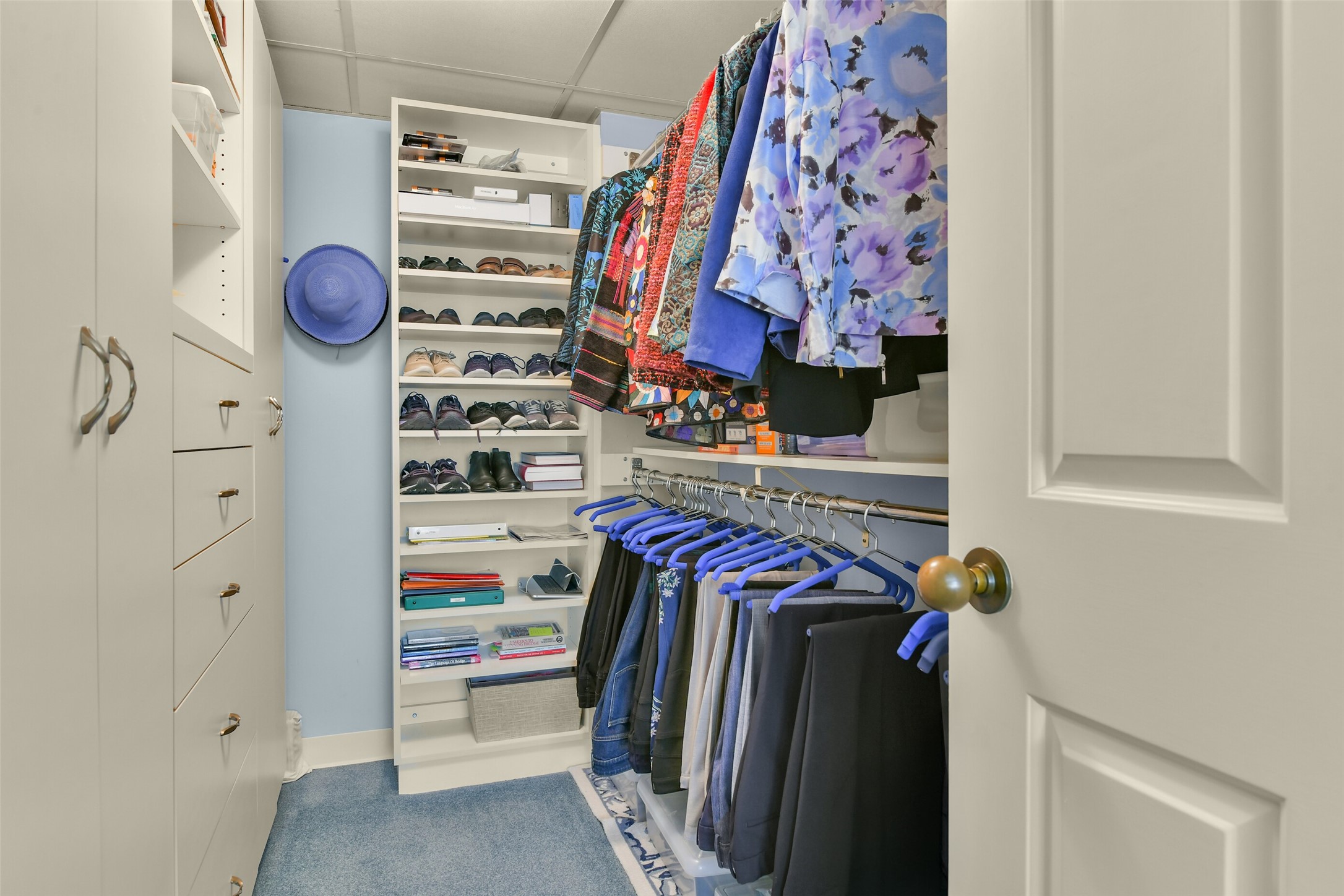Custom built-in storage completes a spacious primary walk-in closet. Custom built-in storage completes a spacious primary walk-in closet.