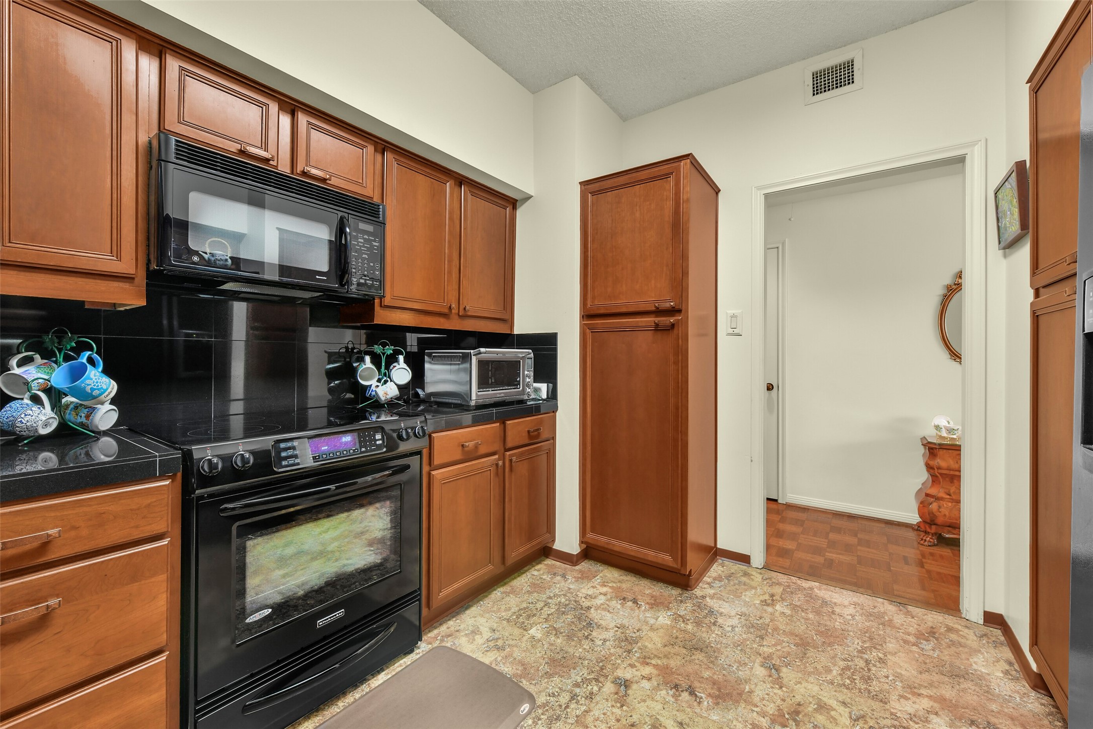 To the side of the entry is a well equipped kitchen with custom built-in cabinetry. To the side of the entry is a well equipped kitchen with custom built-in cabinetry.