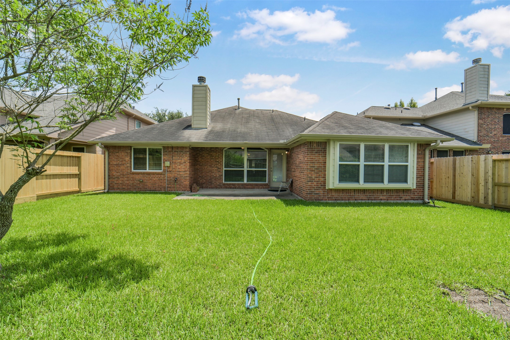 Charming brick home with a spacious, well-maintained backyard perfect for outdoor activities. The patio area offers a cozy spot for relaxation or entertaining.
