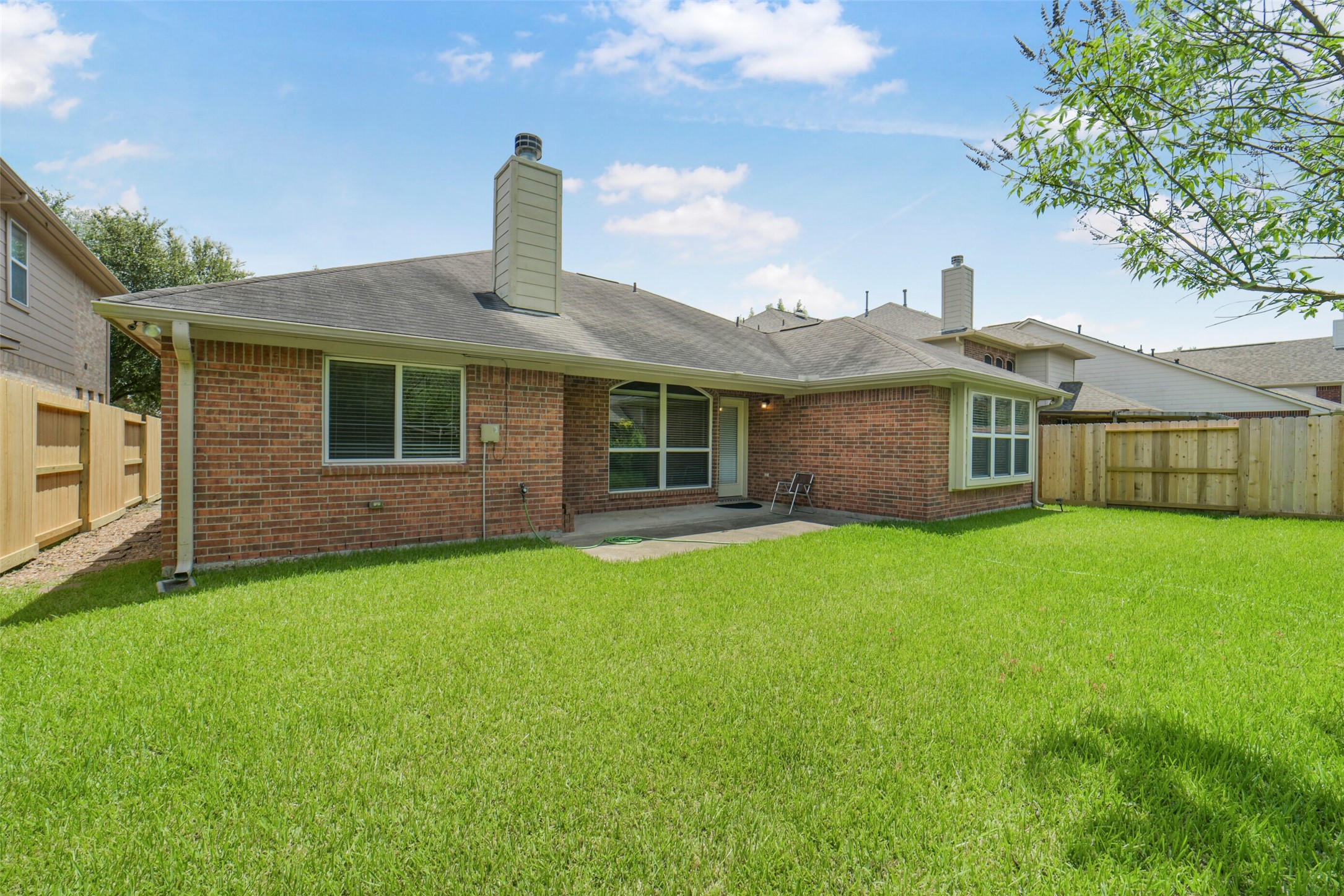 Charming brick home with a spacious backyard, perfect for outdoor relaxation and entertaining.