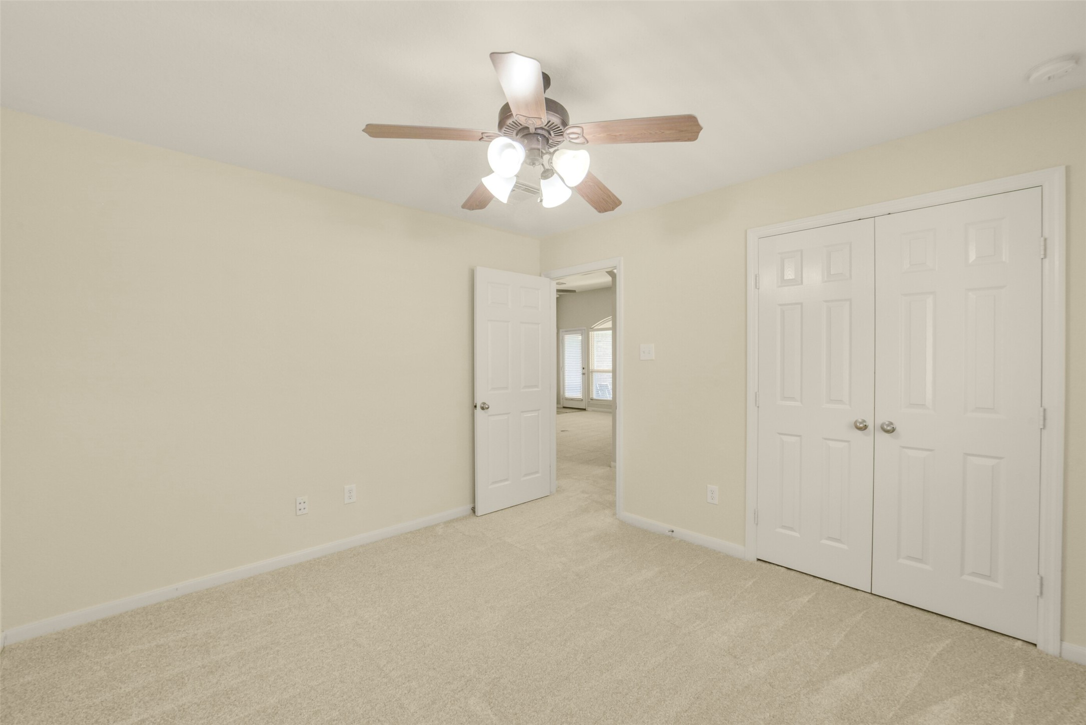 Secondary bedroom with a ceiling fan and dual closets, offering ample storage and comfort.