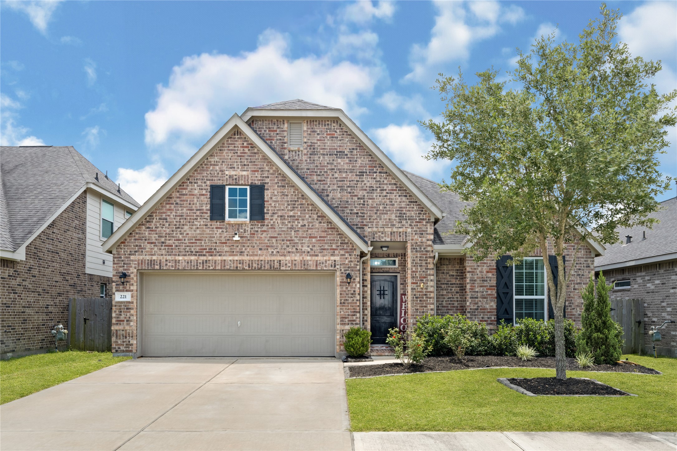 This charming home features a classic brick exterior with a spacious two-car garage. The well-maintained front yard includes a manicured lawn, small shrubs, and a tree, adding to its curb appeal. This charming home features a classic brick exterior with a spacious two-car garage. The well-maintained front yard includes a manicured lawn, small shrubs, and a tree, adding to its curb appeal.