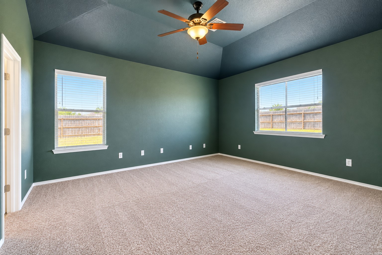 Large primary bedroom looking out to backyard. New carpet.