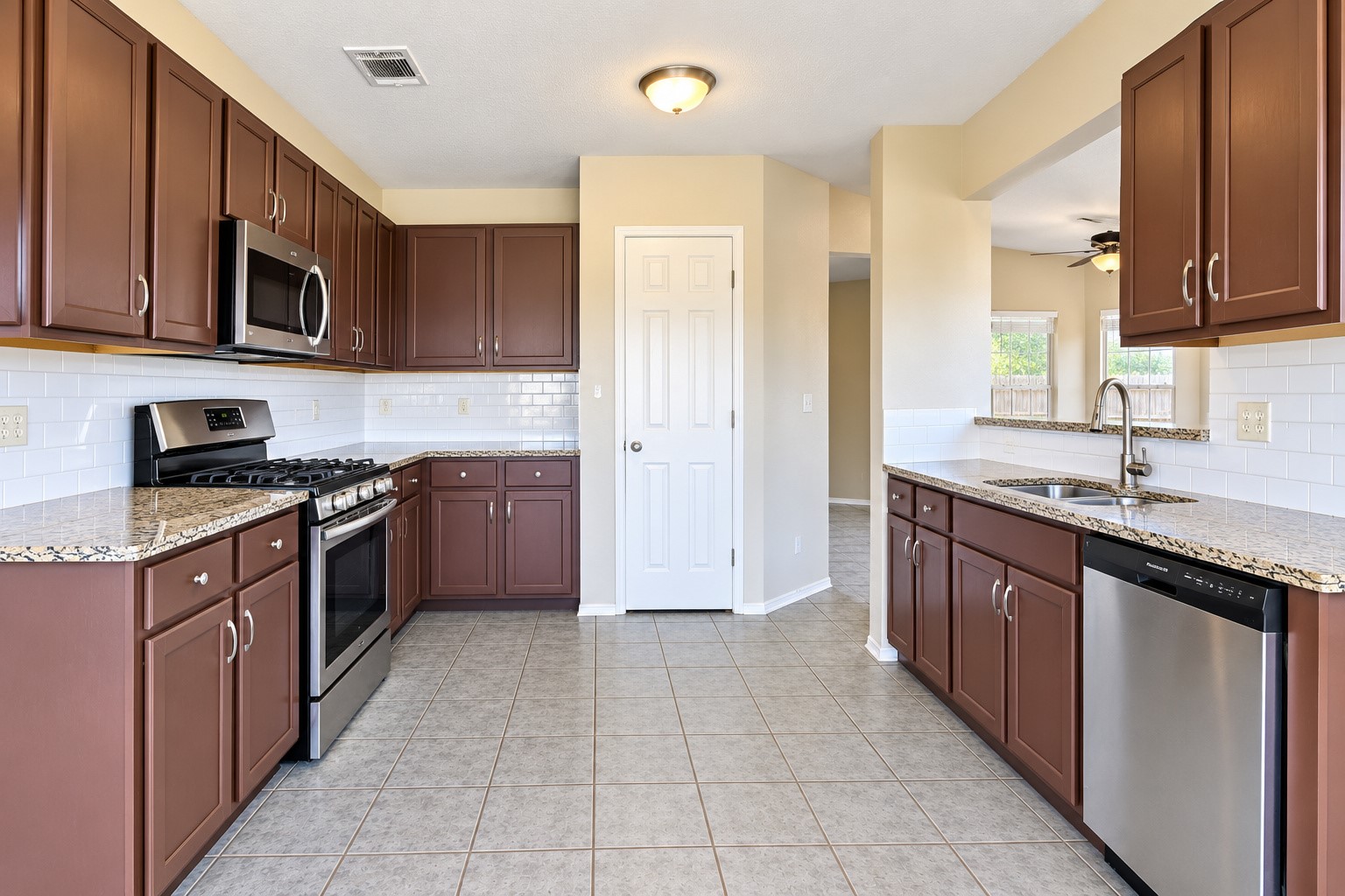 Spacious kitchen with granite counter tops and plenty of cabinets.
