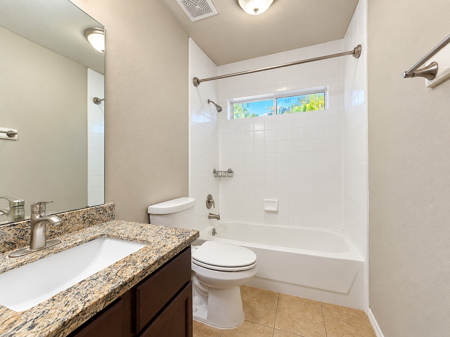 Secondary bathroom with granite counter top that matches the kitchen and primary bathroom countertops.