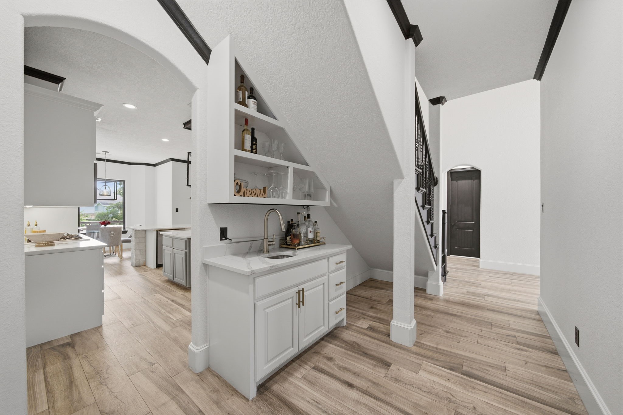 Thoughtfully tucked beneath the stairs, this wet bar adds charm and convenience for effortless entertaining.