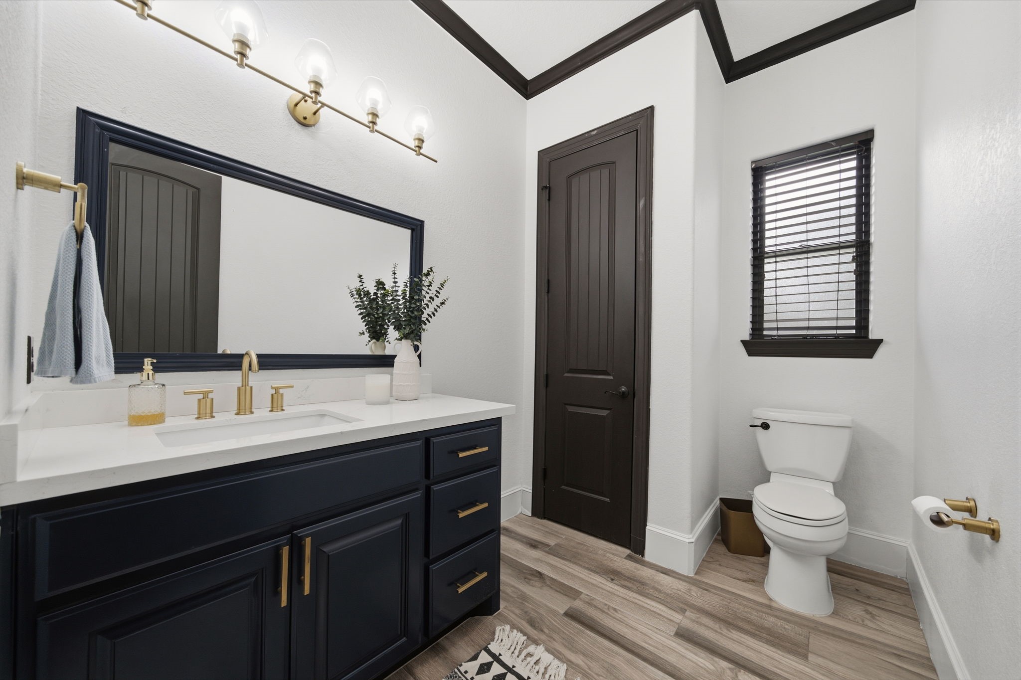 Updated cabinetry, countertops, and lighting give this half bath a fresh, polished look.