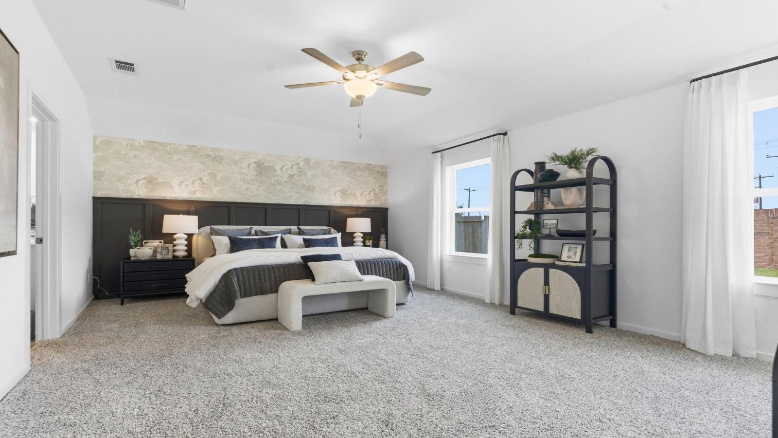A spacious primary bedroom emphasizing open space and natural lighting with large windows.