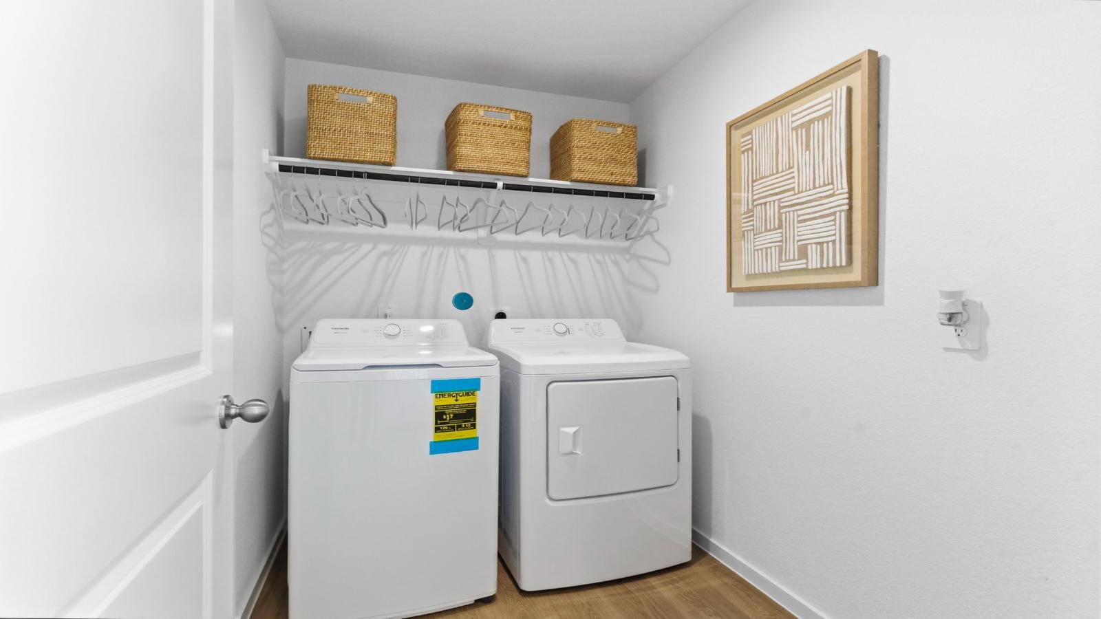 Spacious laundry room with washer and dryer connections, hanging rod, and vinyl wood flooring