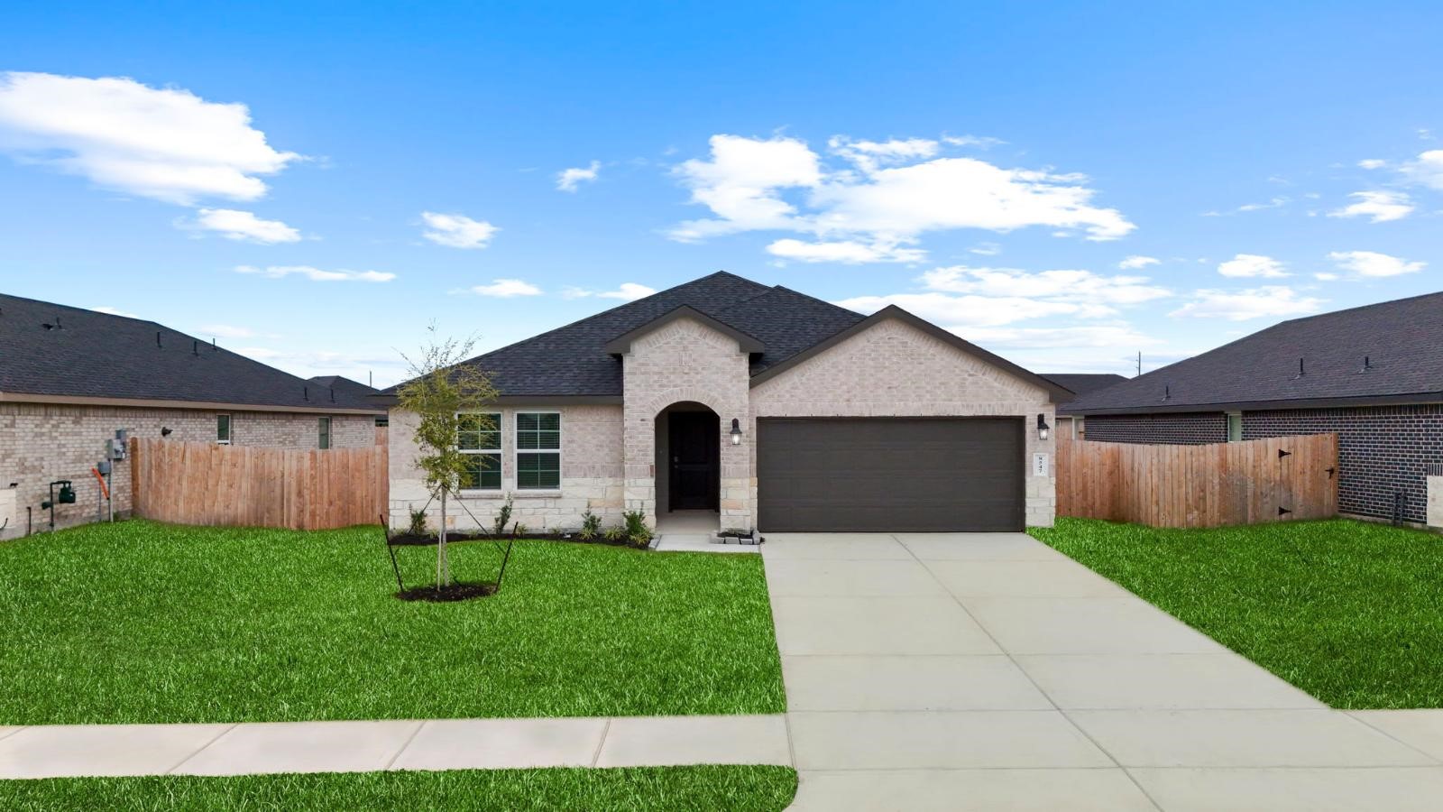 Newly built single story home with traditional architecture, a garage, and landscaped front yard.