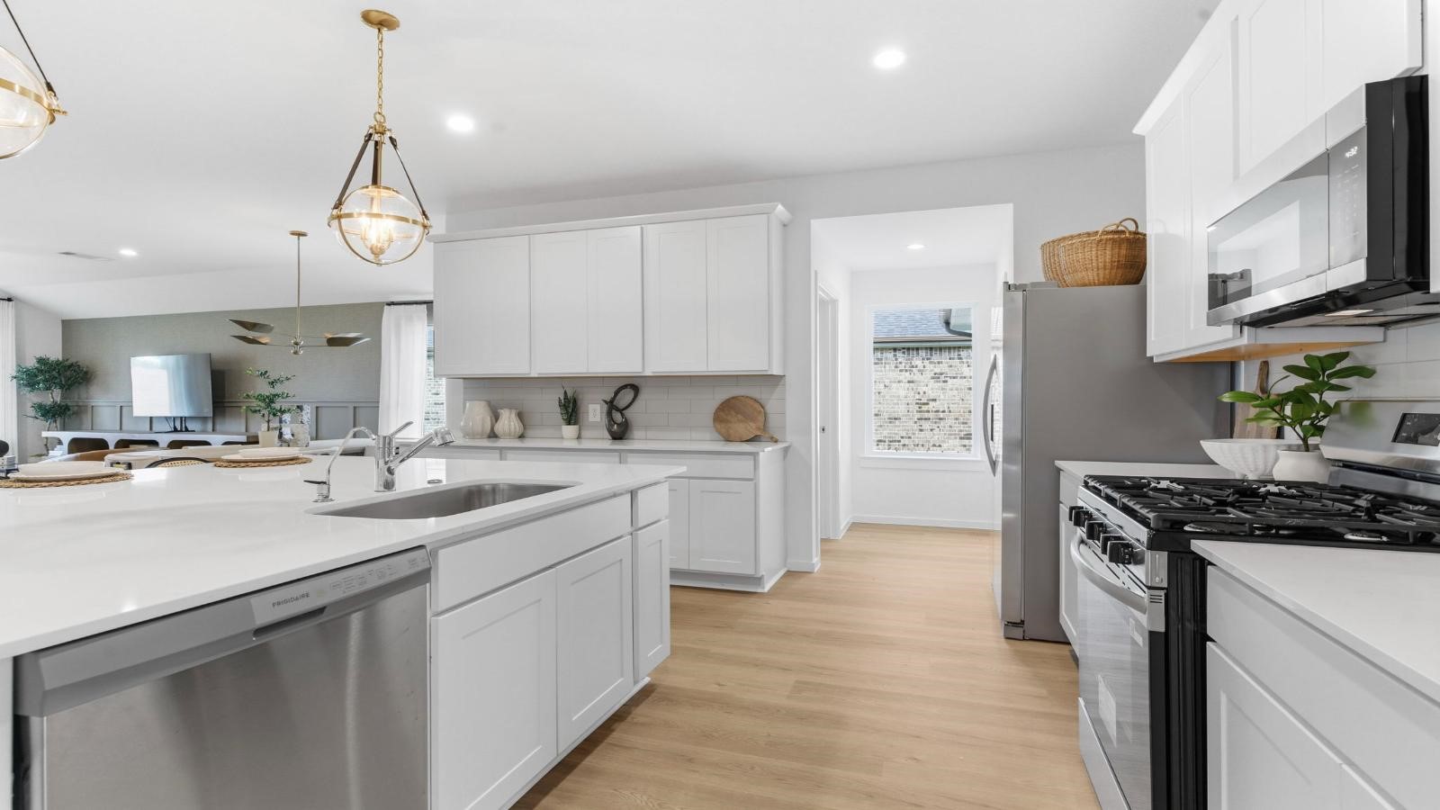 An open concept kitchen with an island with bar seating and access to the living and dining areas. An open concept kitchen with an island with bar seating and access to the living and dining areas.