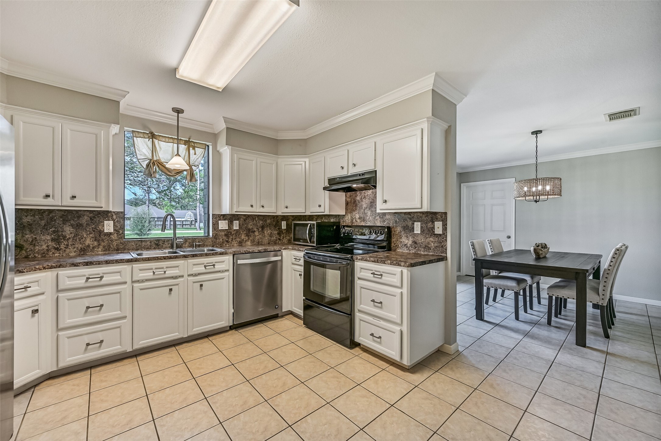Kitchen  Second Residence:
The bright & functional kitchen boasts abundant cabinetry, generous granite-look countertops, and a full appliance package that includes a smooth glass cooktop. A window over the sink brings in natural light and views of the front yard.