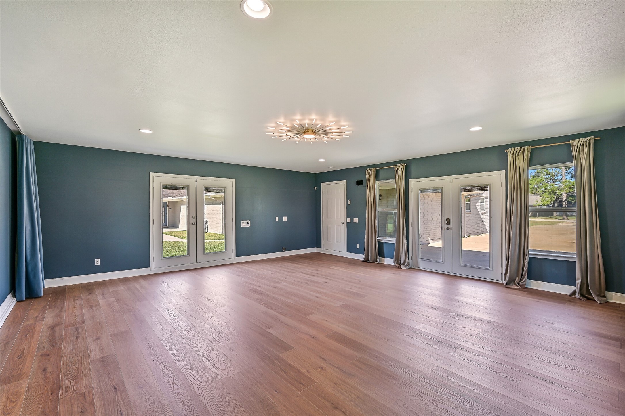 Converted Garage  Finished Flex Space:
Formerly a two-car garage, this fully finished and air-conditioned flex space offers exceptional versatility and scale. Featuring wood-look flooring, recessed lighting, statement ceiling fixture, multiple windows for natural light, and French door access, the space has previously been used as both an art studio and music room.
