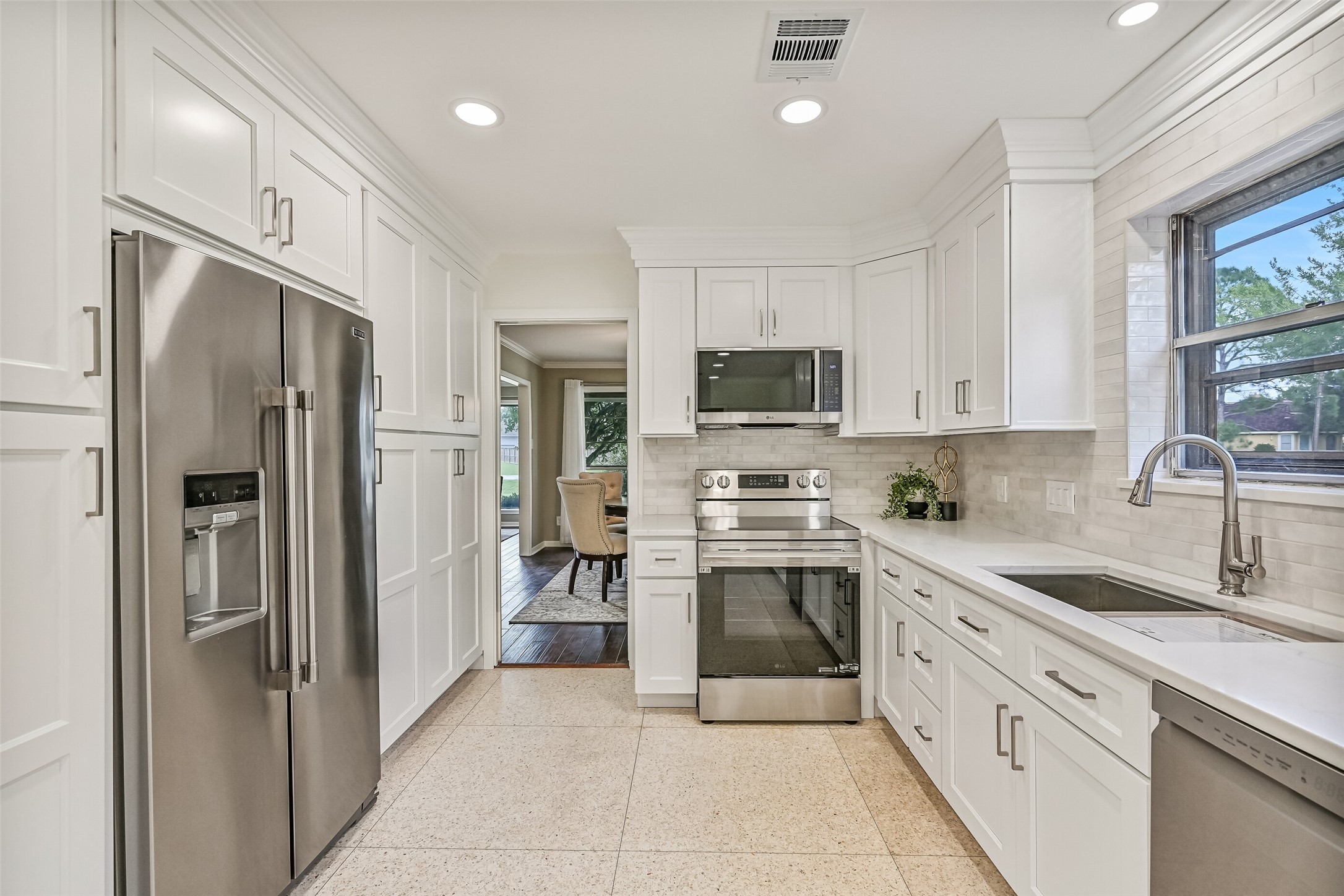 Kitchen  First Residence:
The kitchen offers generous storage and prep space highlighted by extensive cabinetry, quartz countertops, and a functional layout with a smooth glass cooktop & oven, a vent hood microwave, and a dual basin undermount sink with a goosneck faucet.