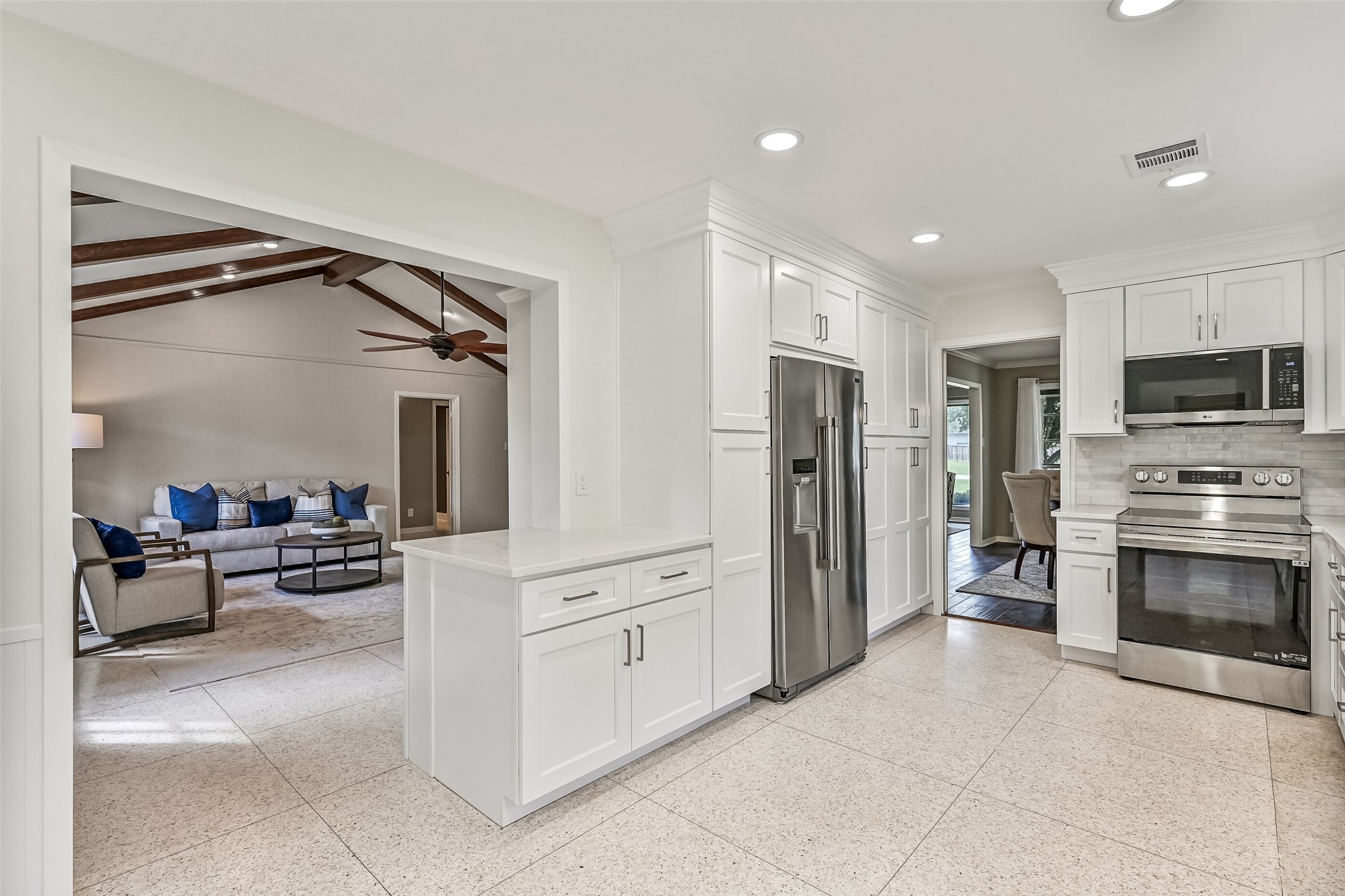 Kitchen  First Residence:
Moving into the masterfully remodeled kitchen in the first residence, note the  crisp, white quartz countertops, marble tile backsplash, all new stainless appliances, and ample new white cabientry offering an abundance of storage space.