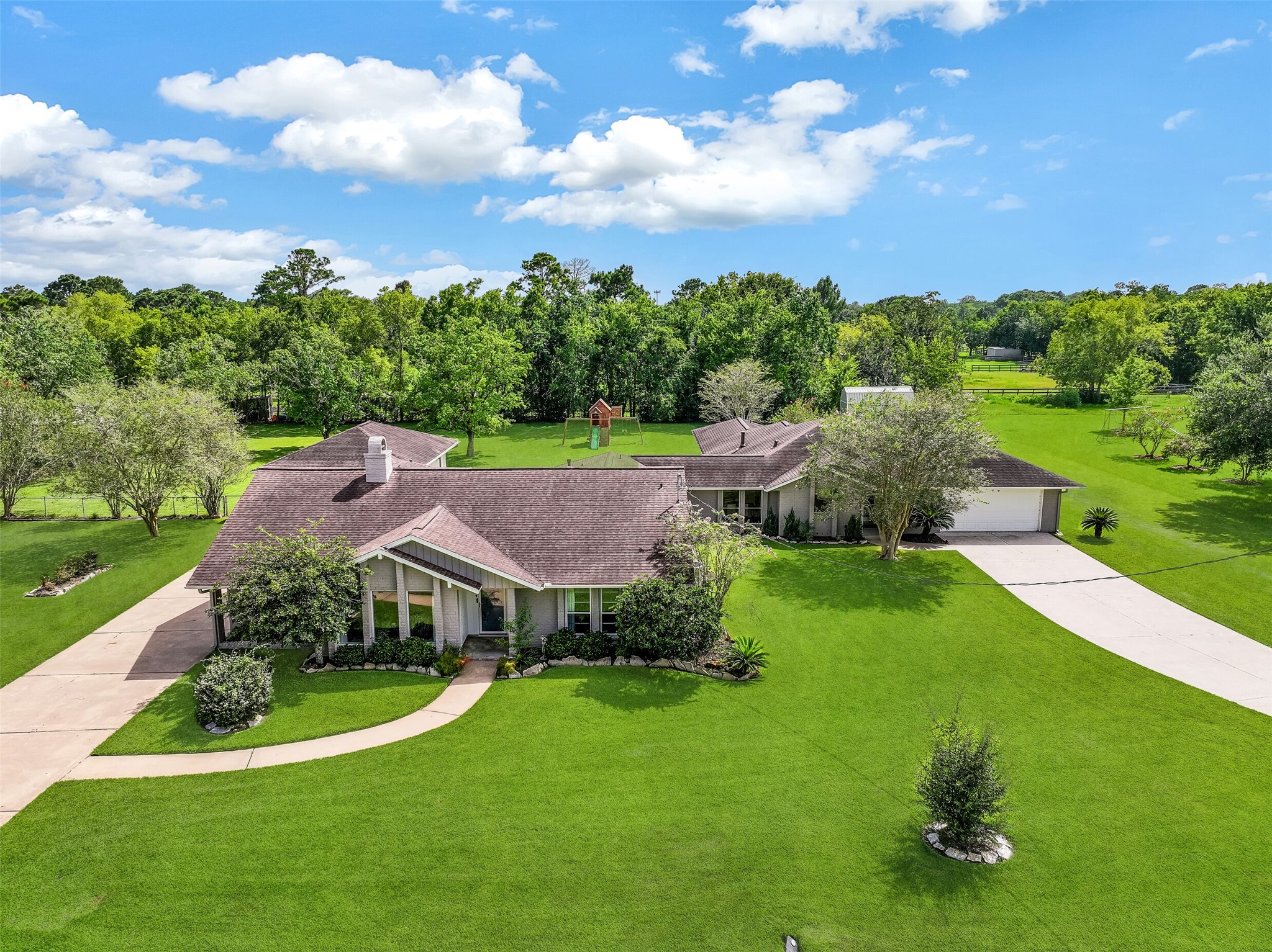 Expansive 1.3-acre Friendswood property boasts a unique dual-residence layout, featuring two complete homes with individual driveways, surrounded by mature trees & wide-open green space. Aerial views showcase the generous lot size with shed, playground, finished garage space, & desirable location on a quiet street with no HOA! Expansive 1.3-acre Friendswood property boasts a unique dual-residence layout, featuring two complete homes with individual driveways, surrounded by mature trees & wide-open green space. Aerial views showcase the generous lot size with shed, playground, finished garage space, & desirable location on a quiet street with no HOA!