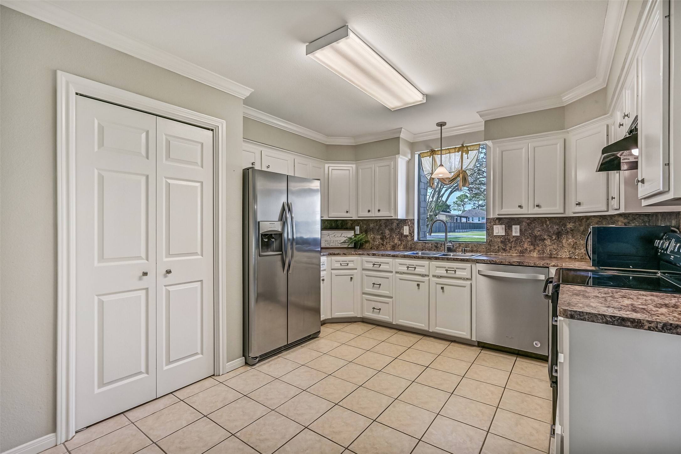 Kitchen  Second Residence:
The bright & functional kitchen boasts abundant cabinetry, generous granite-look countertops, and a full appliance package that includes a smooth glass cooktop. A window over the sink brings in natural light and views of the front yard.