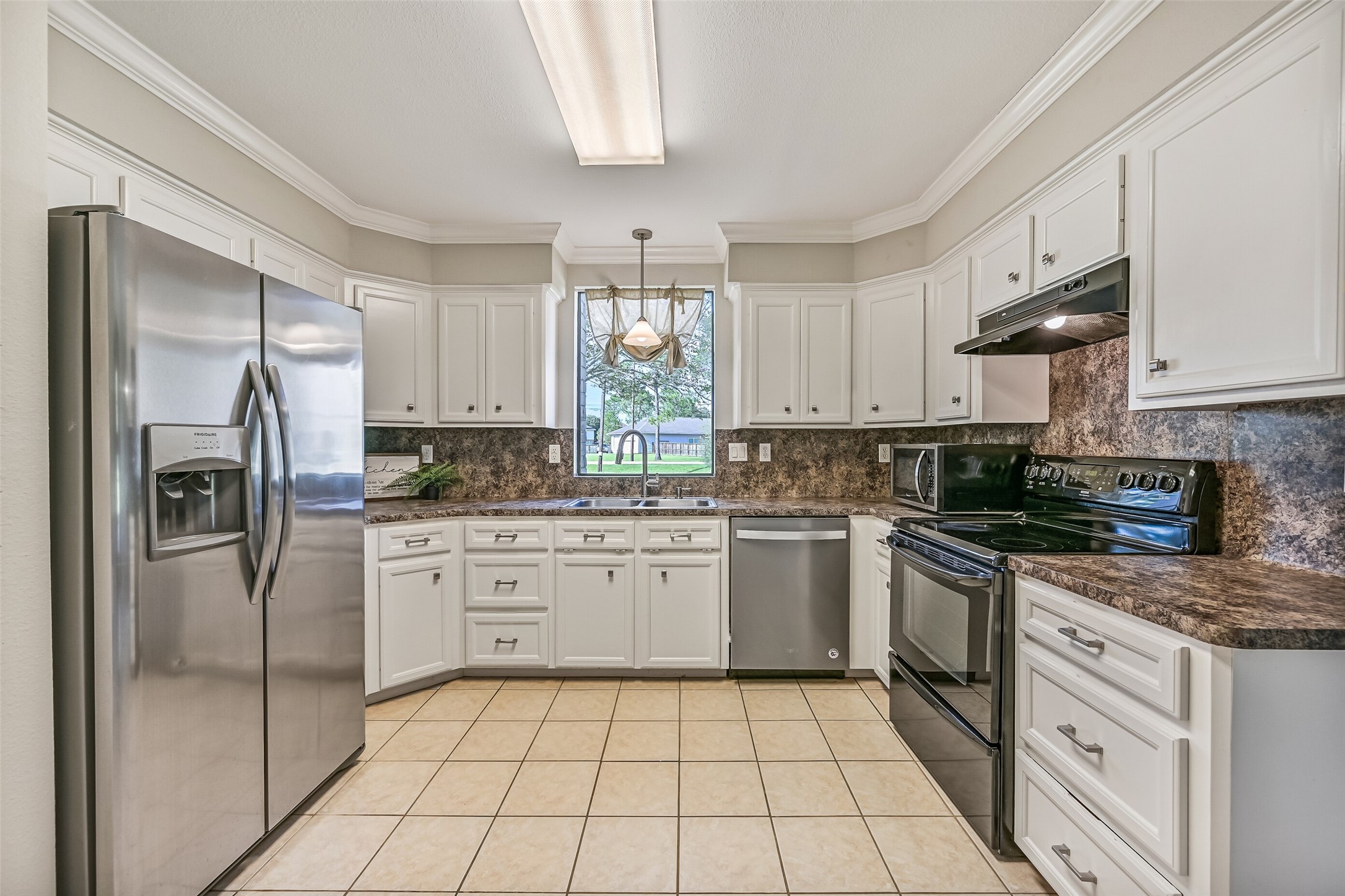 Kitchen  Second Residence:
The bright & functional kitchen boasts abundant cabinetry, generous granite-look countertops, and a full appliance package that includes a smooth glass cooktop. A window over the sink brings in natural light and views of the front yard.