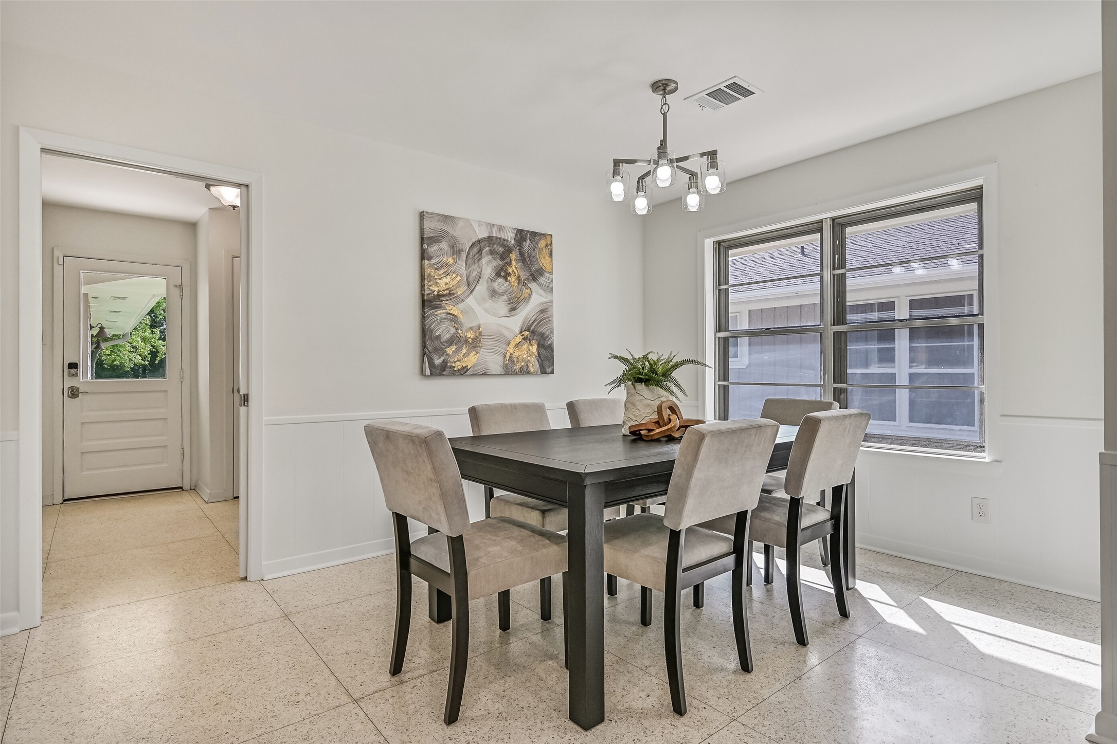 Breakfast Room  First Residence:
The well-appointed breakfast room features fresh paint, a modern, chandelier, and a lengthy brand new quartz-topped built-in buffet along one wall, with direct flow into the mudroom and access to the back door beyond.