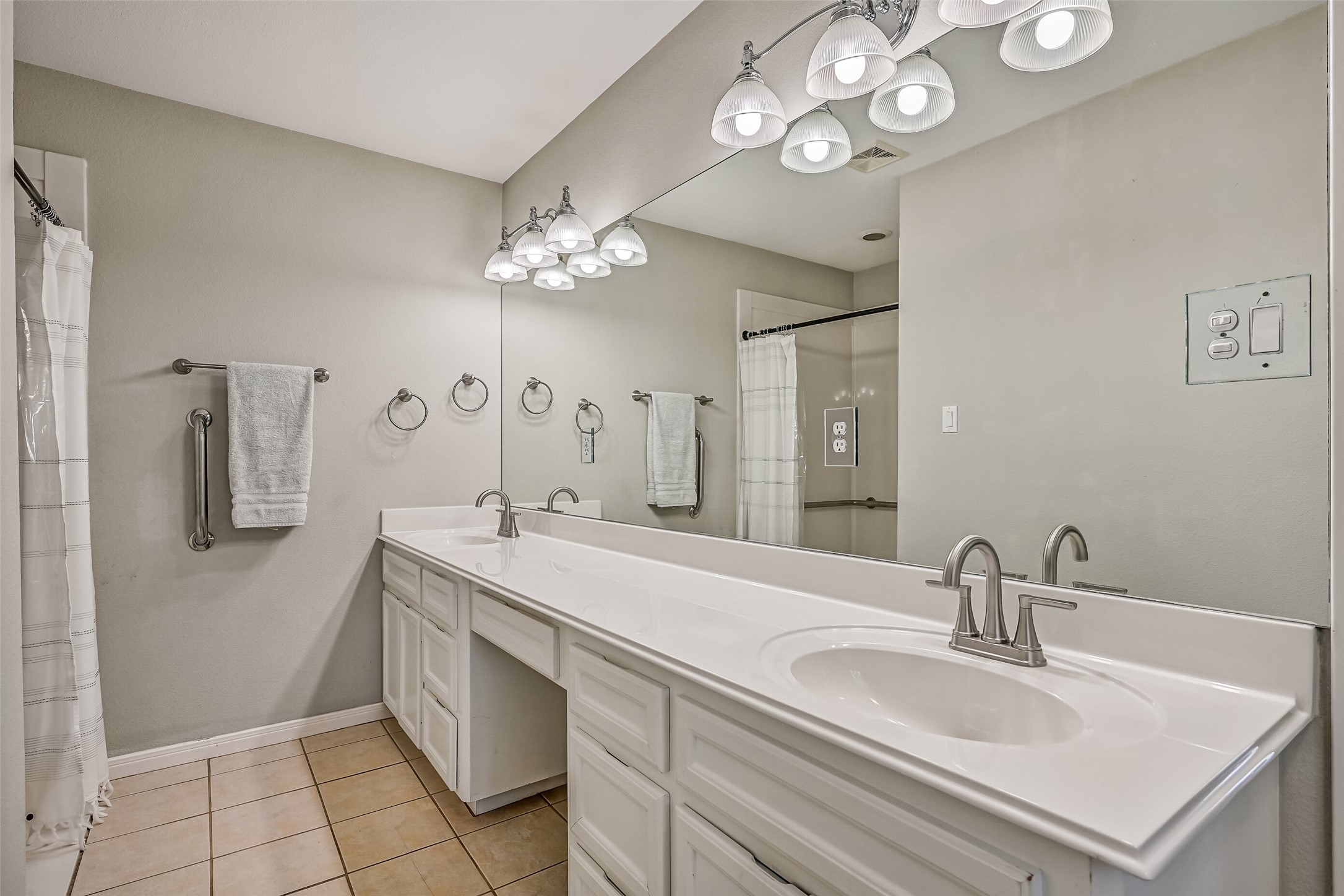Primary Bathroom  Second Residence:
Spacious en suite bath designed with accessibility in mind, featuring an extended dual-sink vanity with generous counter space and storage. An oversized walk-in shower includes thoughtfully placed grab bars and a wide entry for ease of use. Neutral finishes, bright lighting, and tile flooring complete this comfortable and functional retreat.