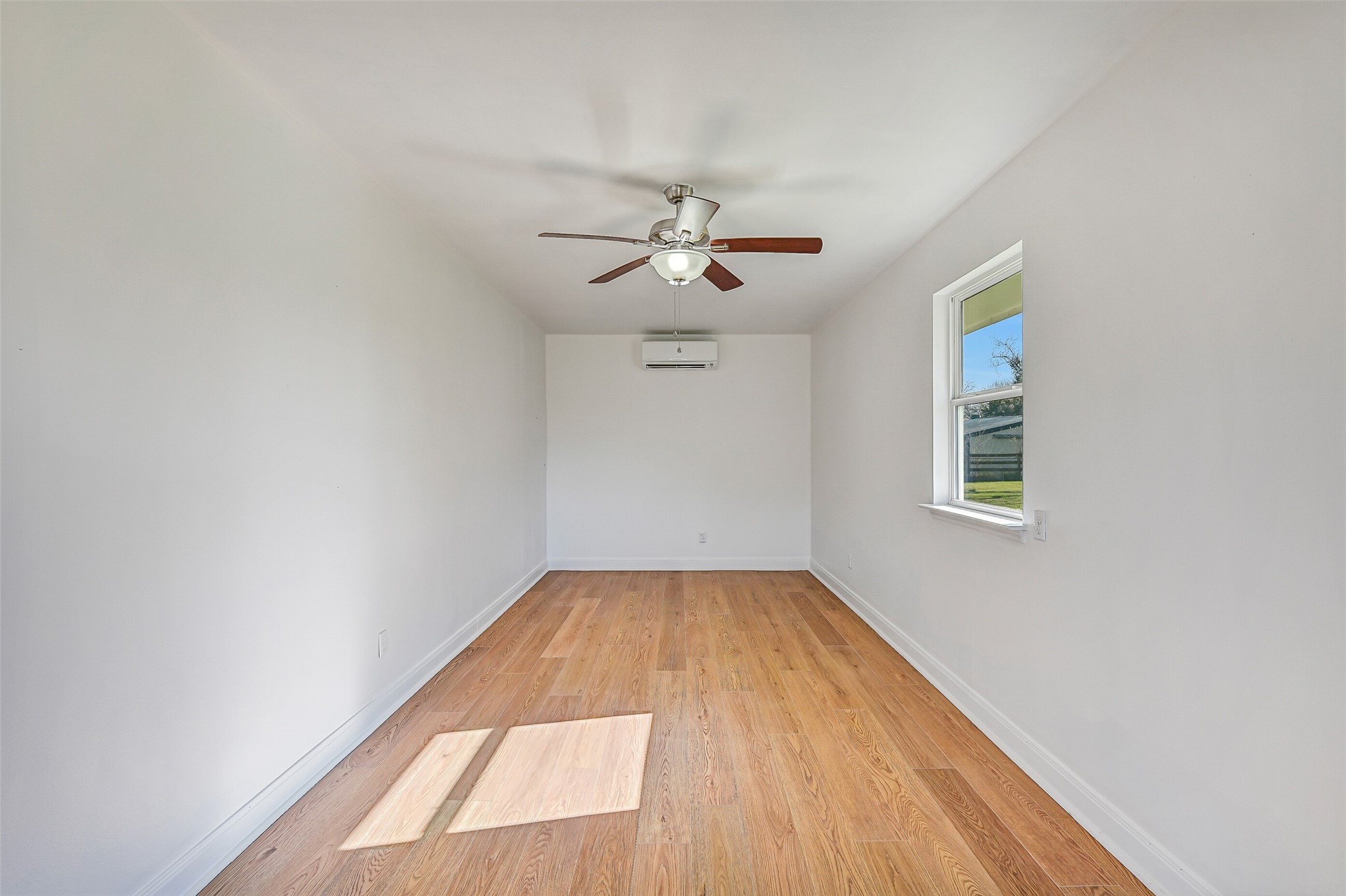 Bonus Room:
This finished and air-conditioned bonus space is accessed via a dedicated exterior door and offers additional flexible square footage. Featuring wood-look flooring, a ceiling fan, and natural light from a window, the room has previously been used as a craft room and would also function well as a hobby space, studio, or private workspace.