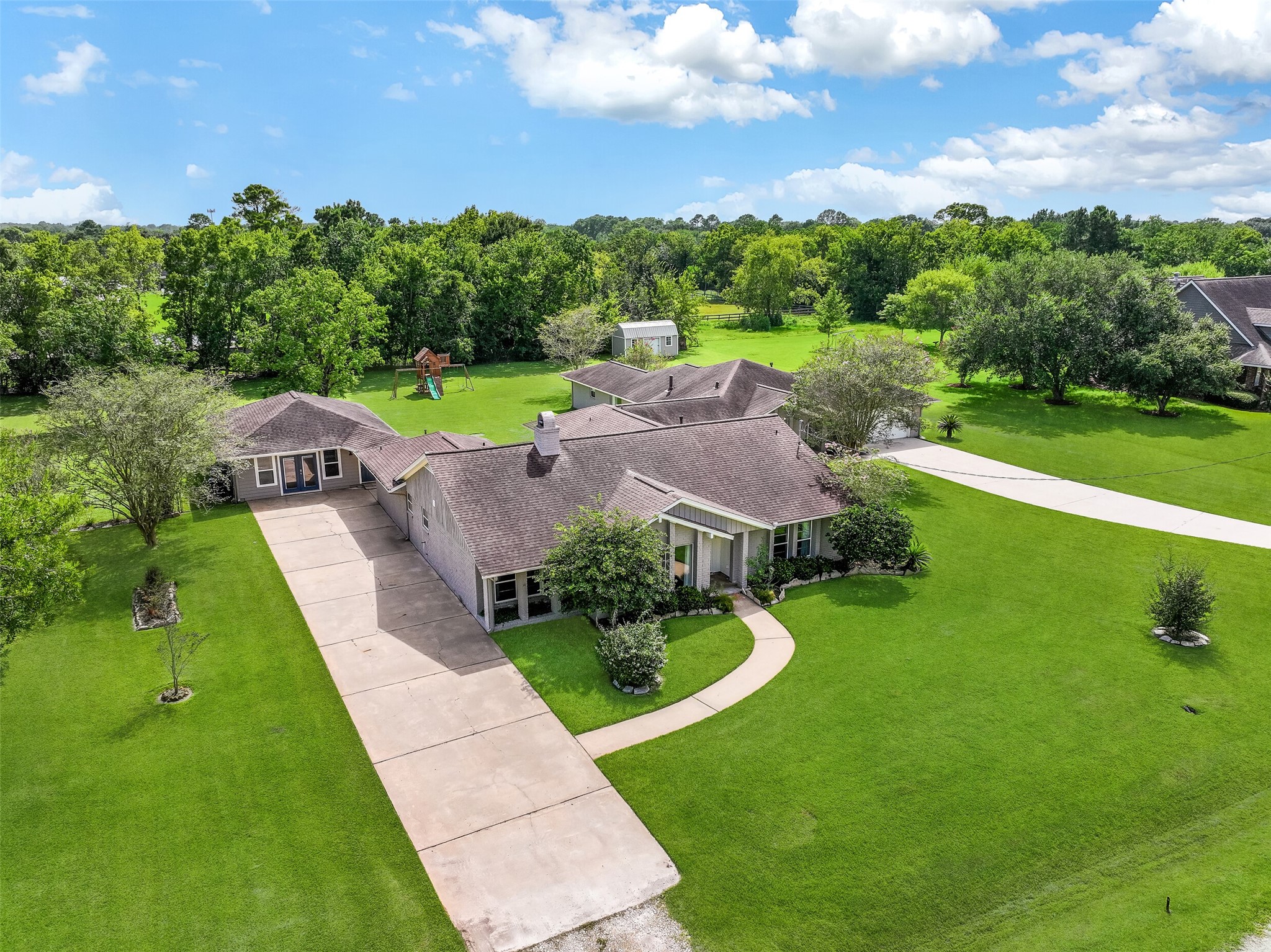 Front / Driveway  First Residence:
A double wide driveway offering ample parking leads to the former two-car detached garage that has been converted into a finished, air-conditioned bonus space, ideal for use as an art studio, music room, gym, or home office.