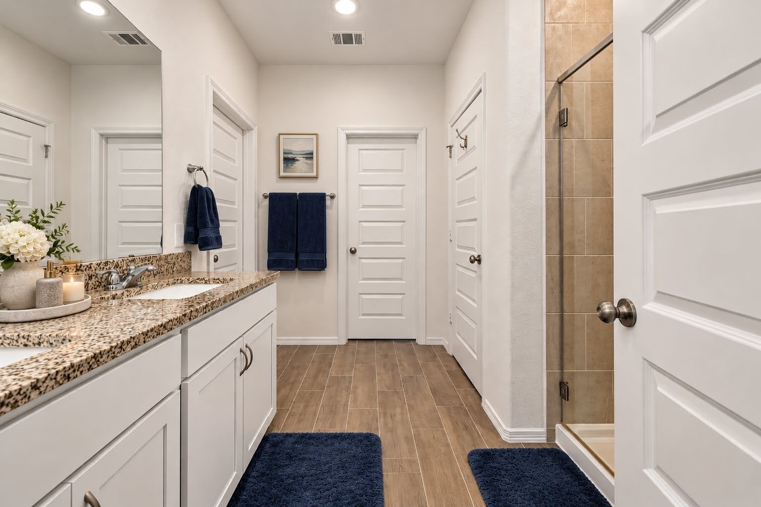 Primary bath with granite counter tops, 2 sinks, glass shower enclosure, separate water closet, and modern 5 panel interior doors.