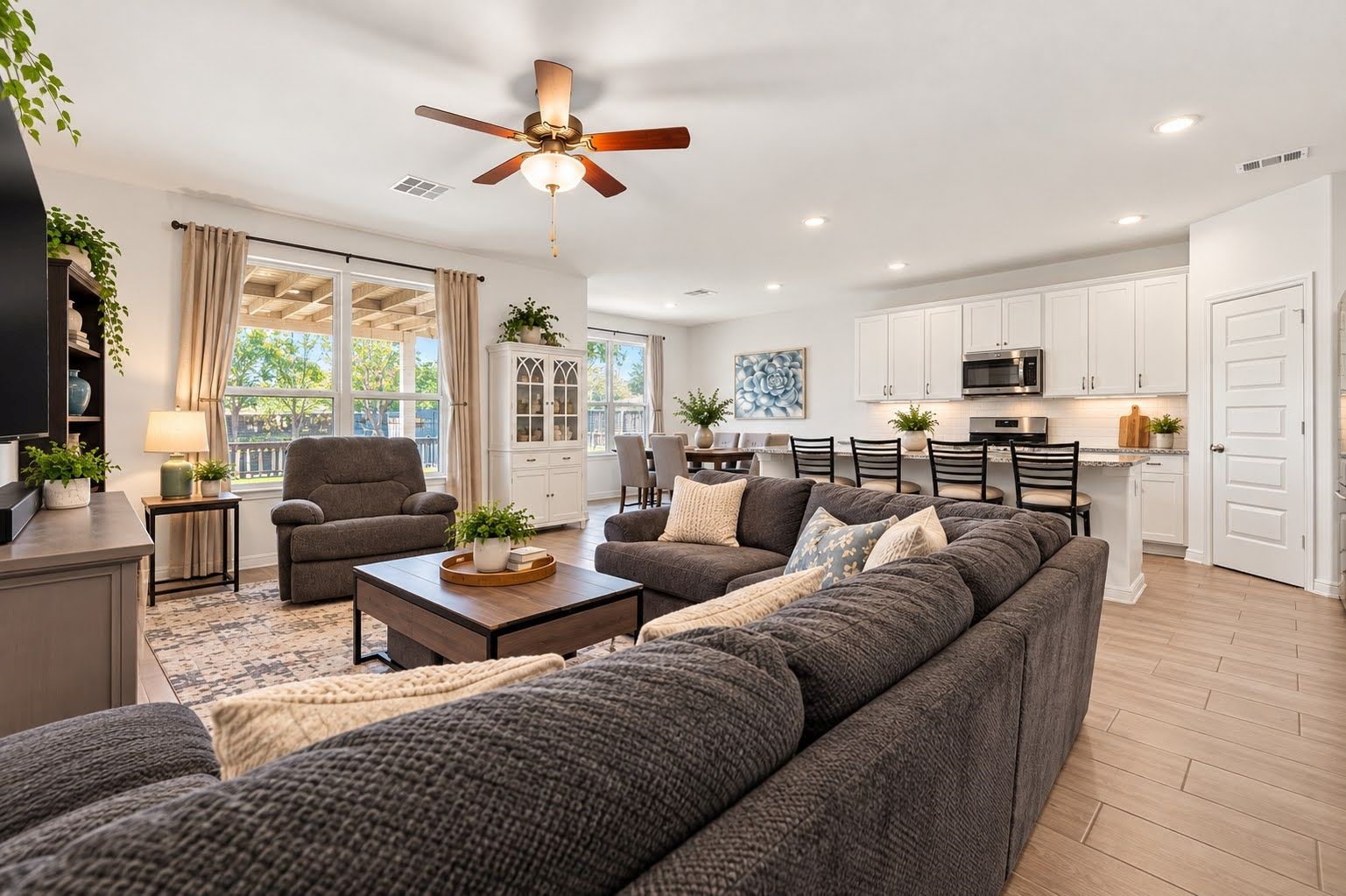 Family room open to kitchen, with ceiling fan and easy to care for wood look tile. Family room open to kitchen, with ceiling fan and easy to care for wood look tile.