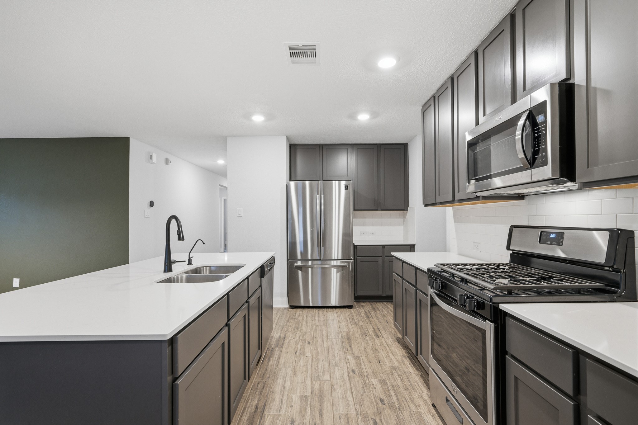 Discover culinary elegance in this modern kitchen, featuring sleek stainless steel appliances, expansive countertops, and stylish cabinetry, perfect for both everyday meals and entertaining.