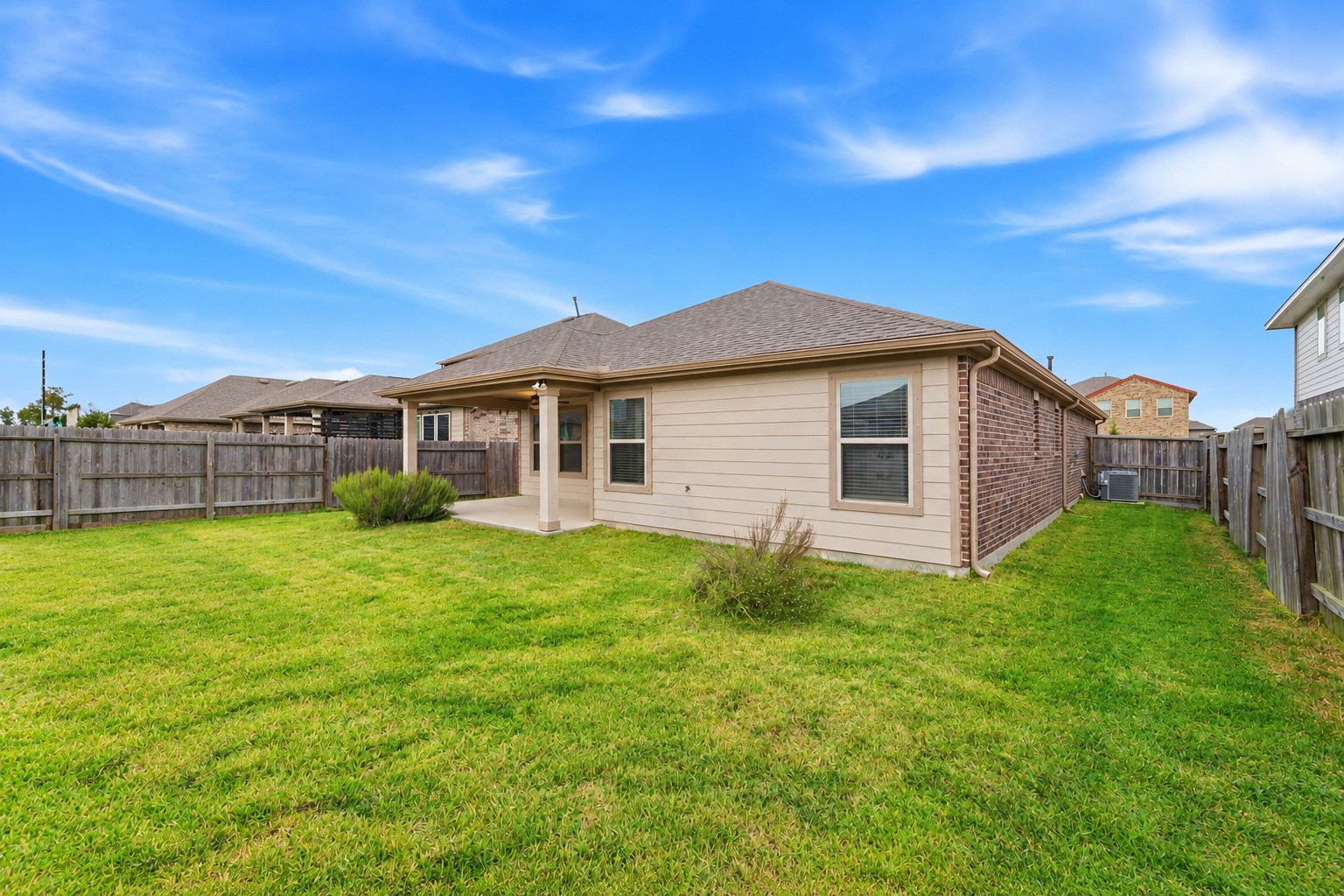 Spacious and inviting, this backyard boasts lush green grass, perfect for family fun and relaxation.