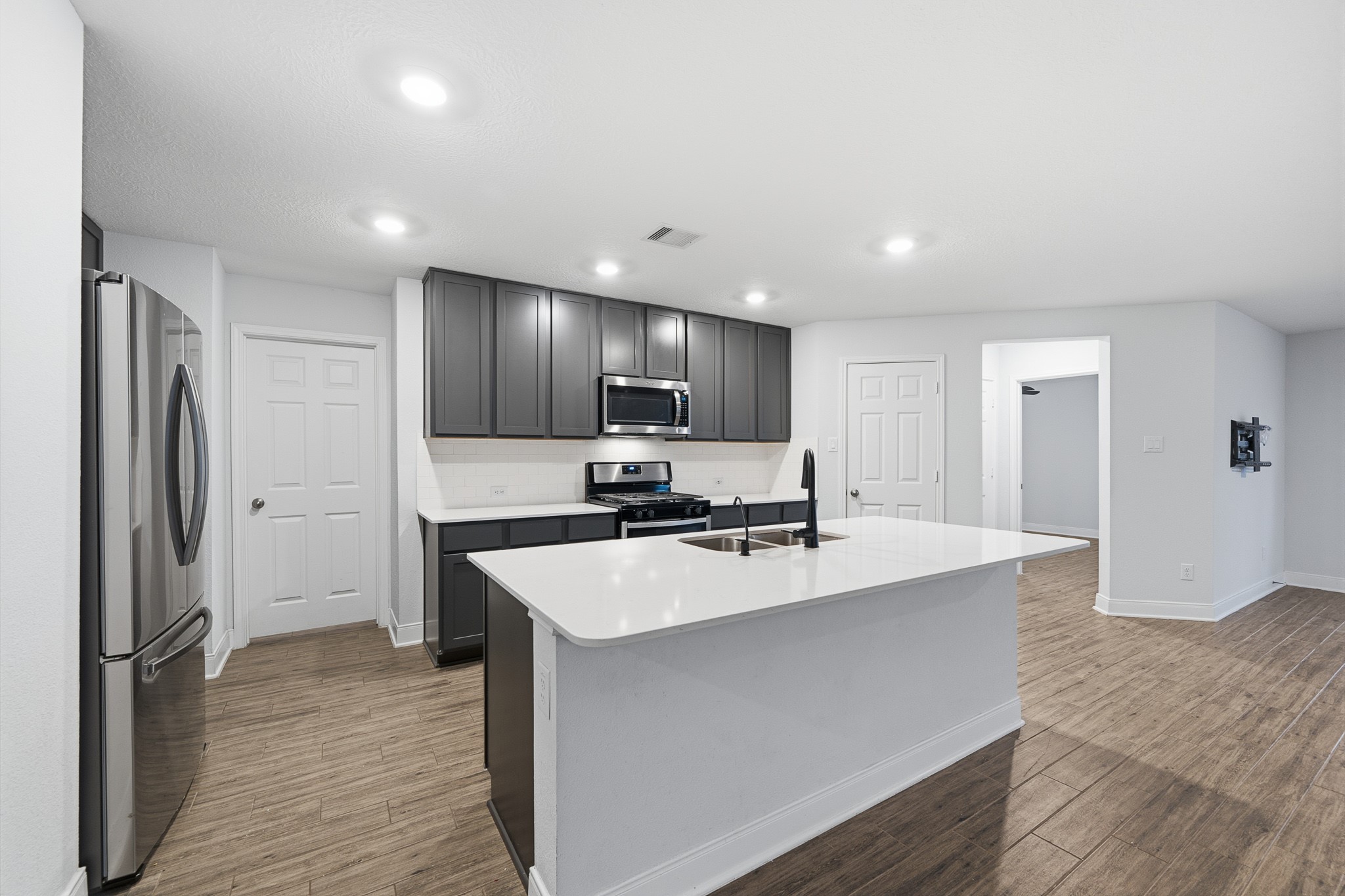 Discover a sleek, modern kitchen featuring elegant cabinetry, stainless steel appliances, and a spacious island perfect for culinary adventures and gatherings.